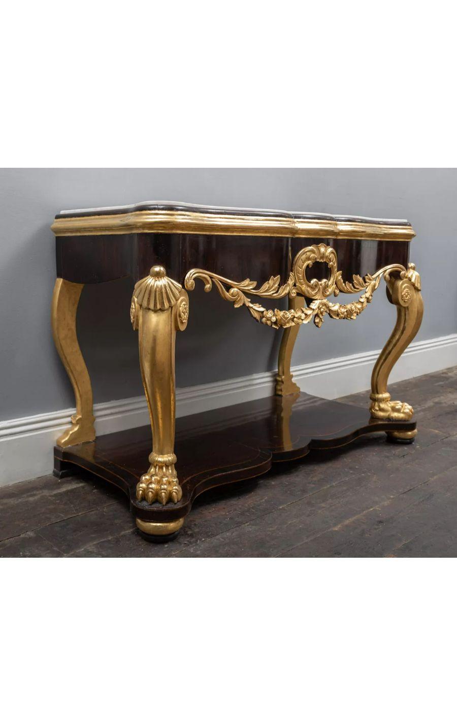 French Régence Style dark wood and gilt Console Table, circa 1860

An antique French Régence style wooden table with gold gilded elements and a white Statuary Carrara marble top.

The serpentine shaped frieze is overlaid with carved and gilded