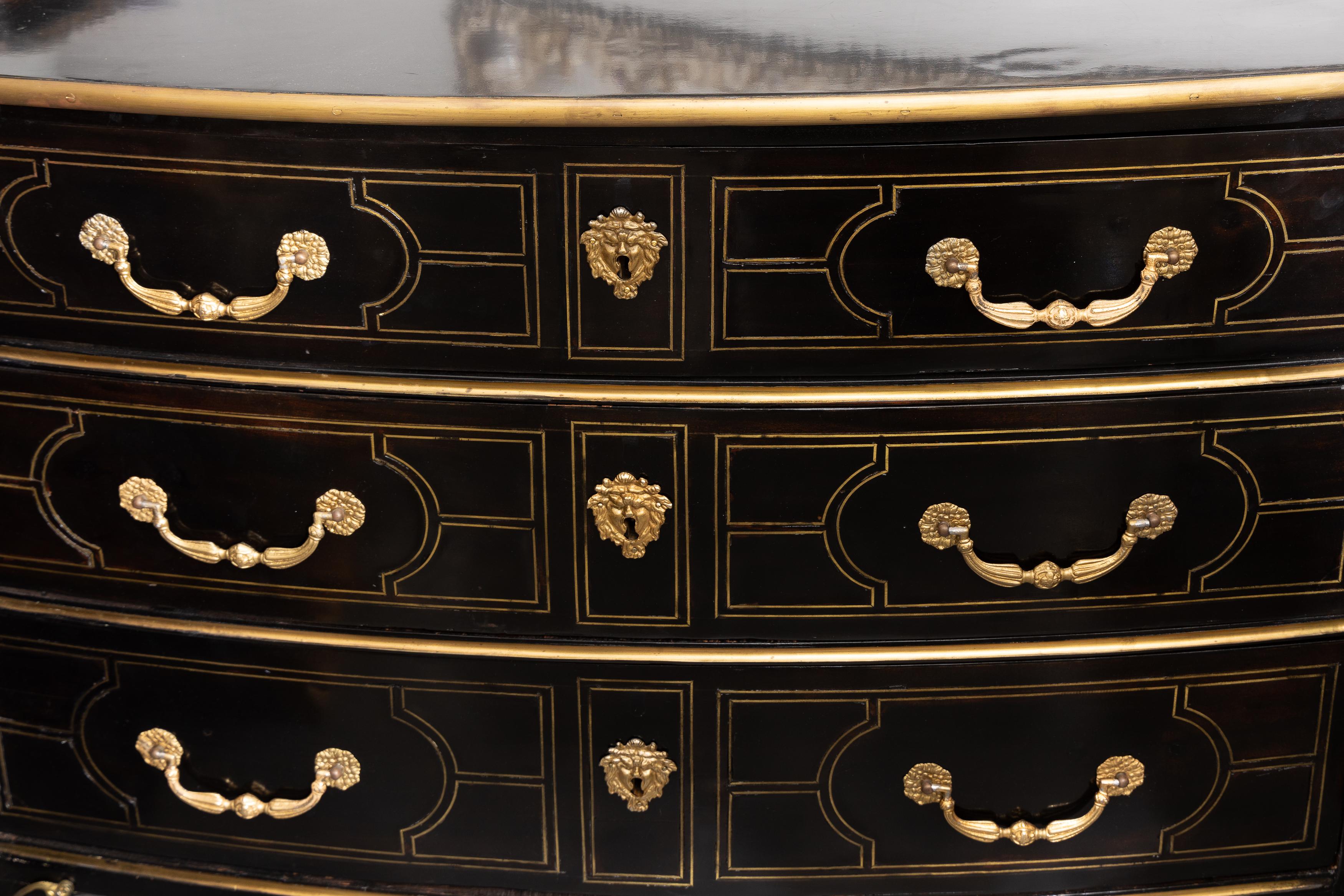 This is a stylish Regence style ebonized commode with brass inlay and brass ornamentation on the frieze and feet, 19th century. The commode contains three long graduated drawers, 19th century.