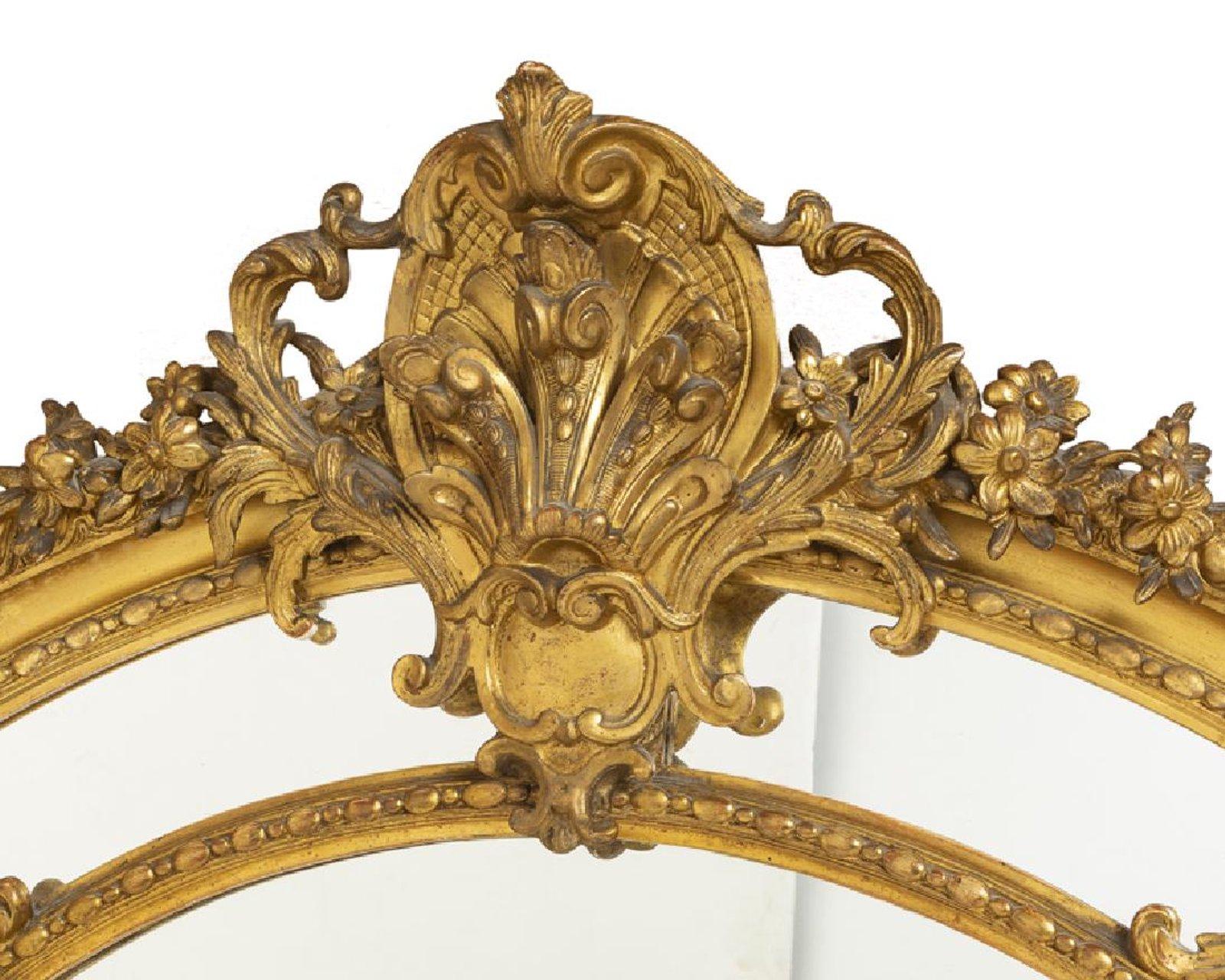 Exceptional 19th century French Regence style gilded figural mirror with beveled glass plate.

The magnificently carved foliate-inspired top of the mirror is centered by scrolling acanthus shell and flanked by beautifully carved gilt sculptures of