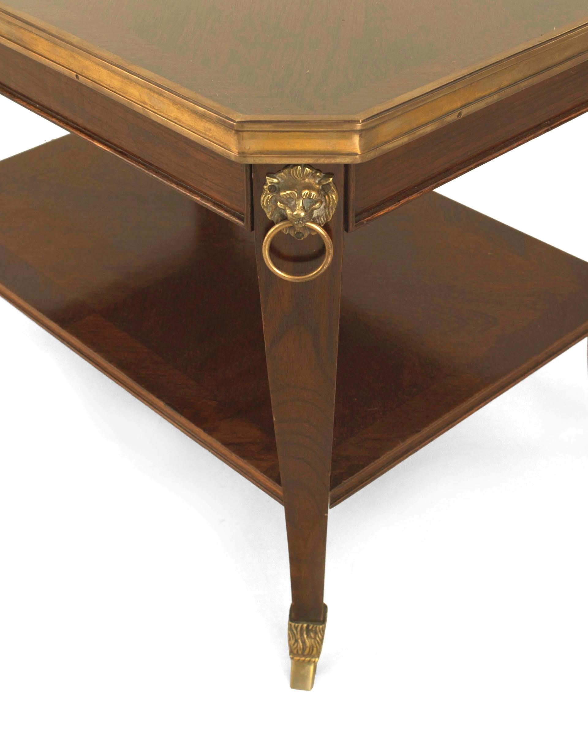 French 1940s (Regency style) mahogany coffee table with a shelf and bronze lion head trim, hoof feet, and an edge supporting an inset glass top (stamped: JANSEN).

Maison Jansen was a Paris-based interior decoration office founded in 1880