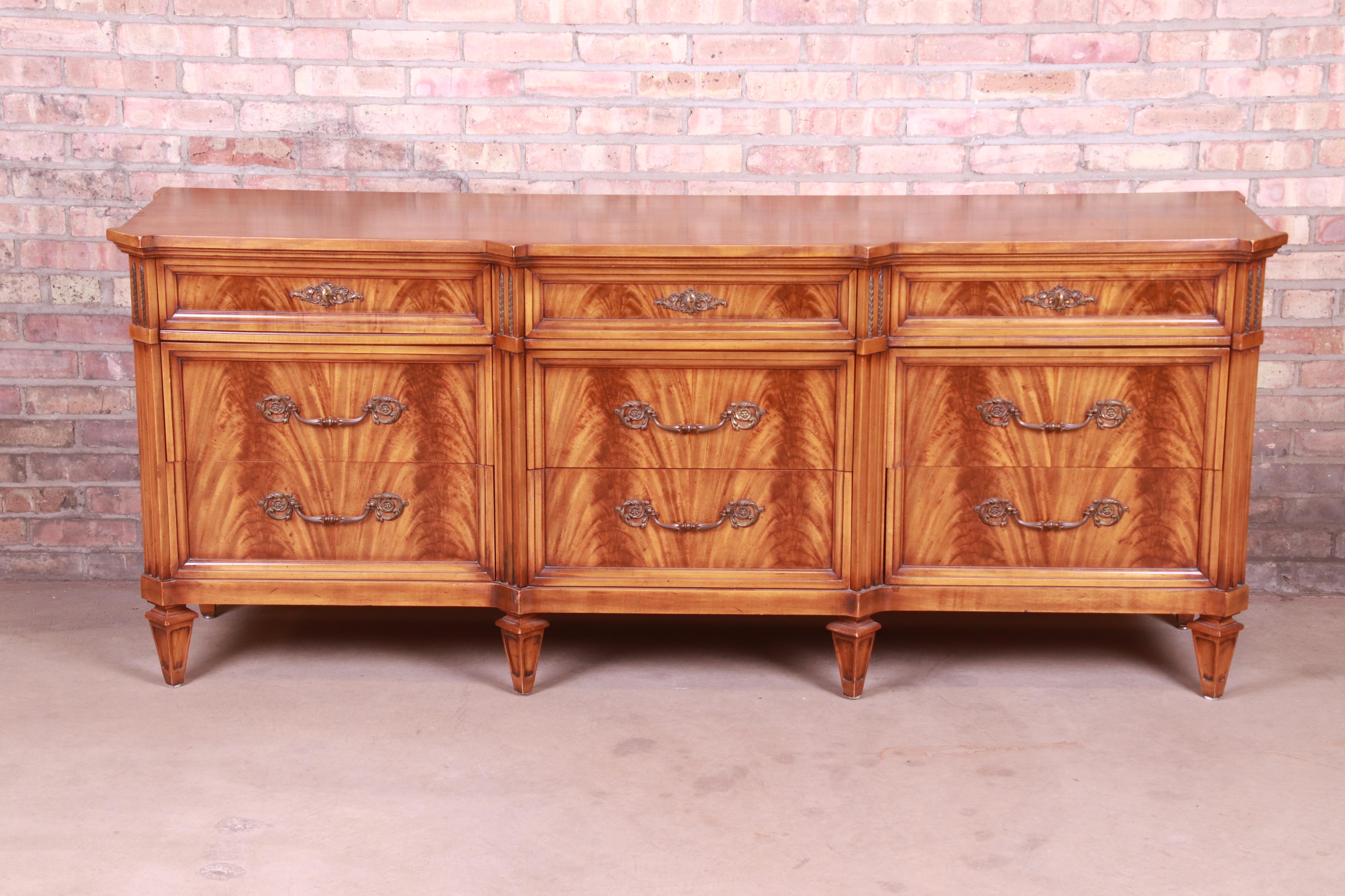 A gorgeous French Regency style nine-drawer dresser or credenza

By J.L. Metz

USA, 1960s

Book-matched flame mahogany, with original brass hardware.

Measures: 77.25