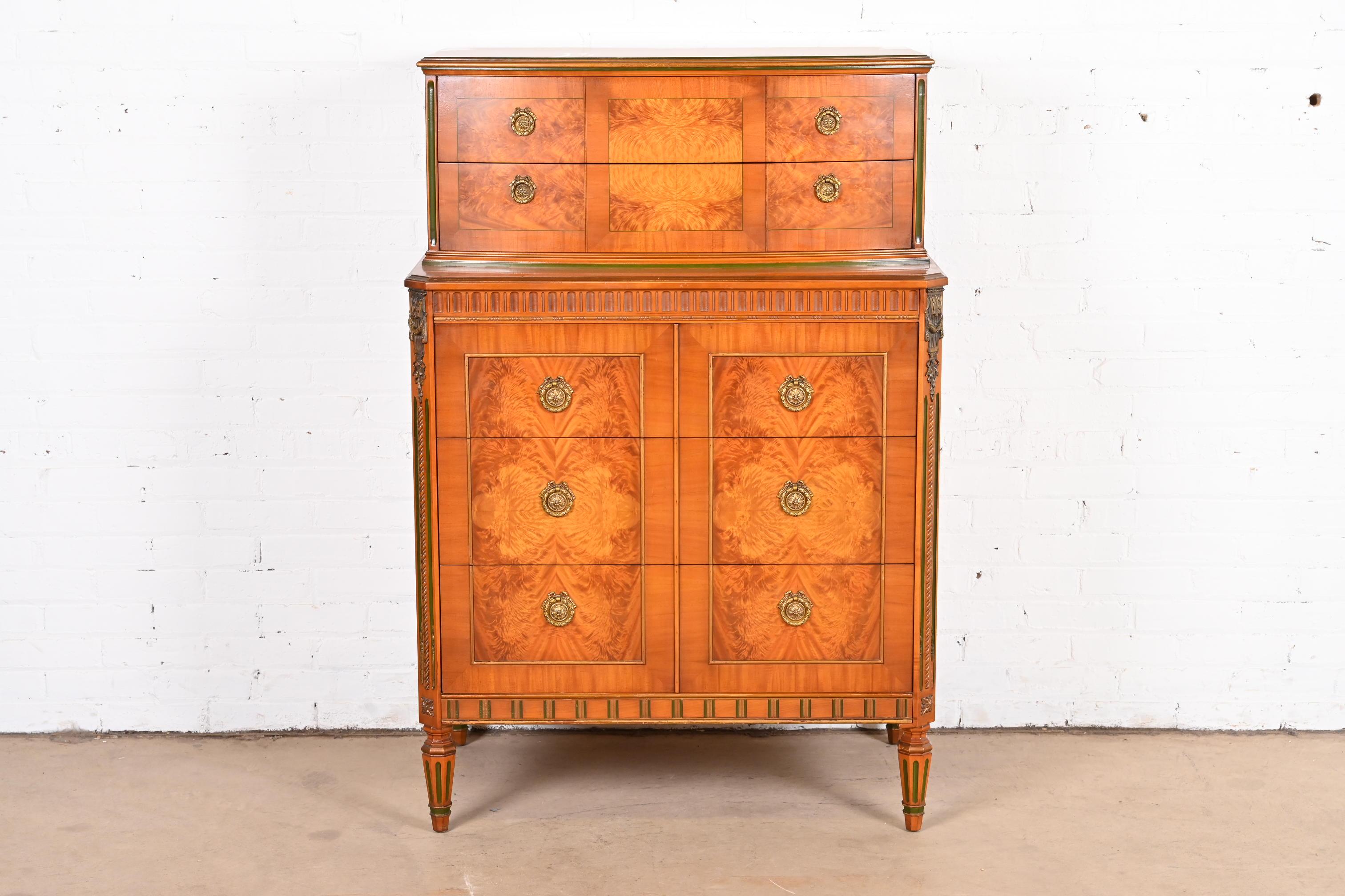 A gorgeous vintage French Regency Louis XVI style highboy dresser or chest of drawers

Attributed to Romweber

USA, Circa 1930s

Satinwood, with beautiful book-matched burl wood top and front, gold gilt and green painted details, and original