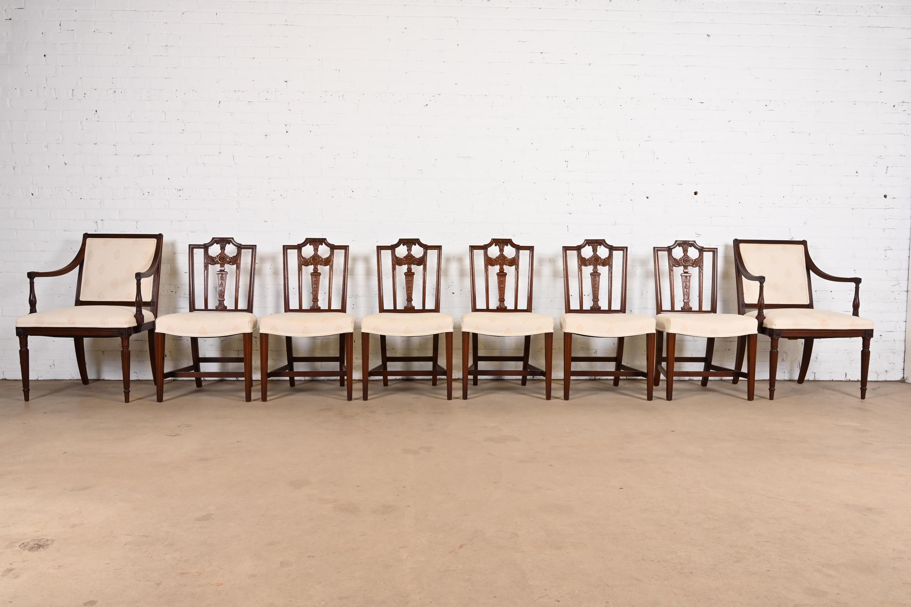 A gorgeous set of eight French Regency Louis XVI style dining chairs

In the manner of Henredon

USA, Circa 1980s

Sculpted solid mahogany frames, with upholstered seats.

Measures:
Side chairs - 20
