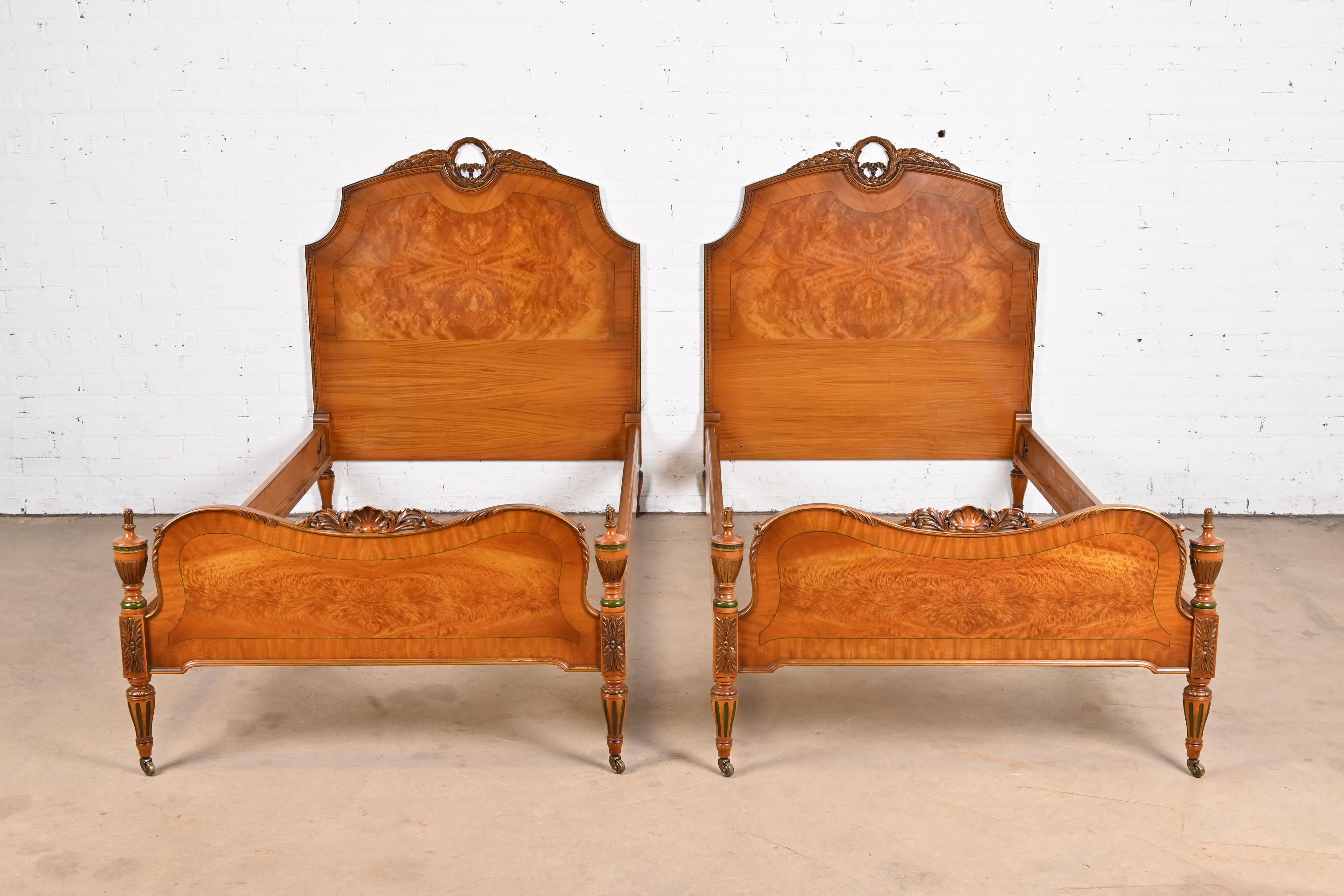 A gorgeous pair of French Regency Louis XVI style twin beds

In the manner of Romweber

USA, circa 1930s

Carved satinwood, with stunning inlaid burl wood, and green and gold painted details.

Each bed measures: 41.75