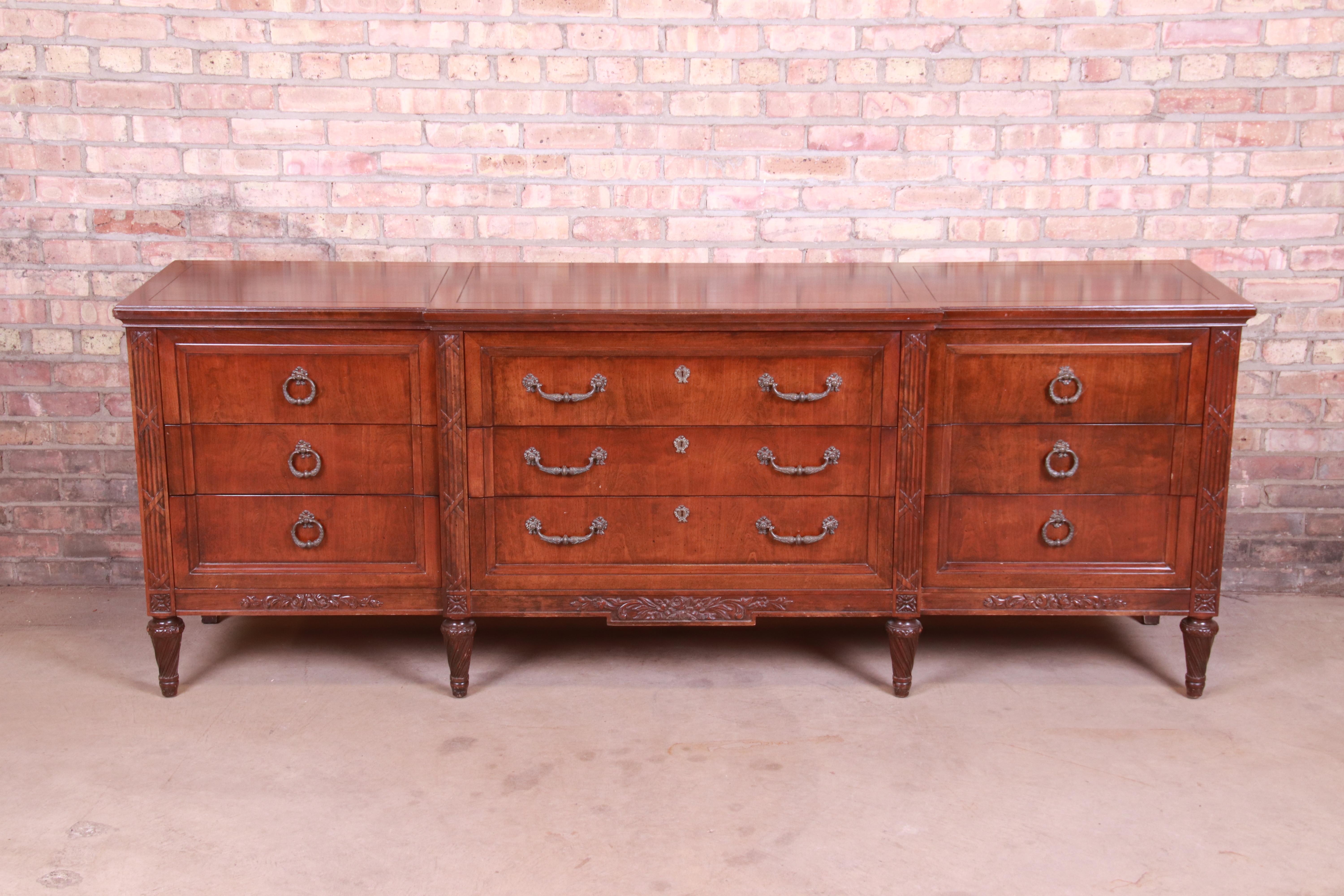 A gorgeous French Regency Louis XVI style long dresser or credenza

Attributed to Henredon

USA, circa 1960s

Carved walnut, with original brass hardware.

Measures: 86