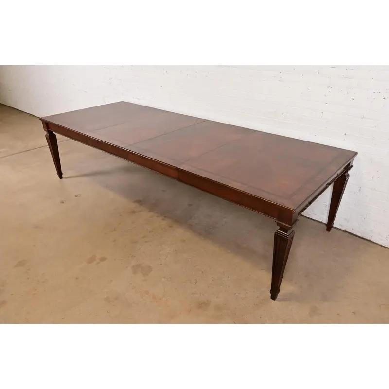Una excepcional mesa de comedor extensible estilo Luis XVI de la Regencia francesa

Por Ethan Allen

EEUU, circa finales del siglo XX

Madera de cerezo, con magníficas bandas de madera burlada, y cajones para cubiertos forrados de fieltro con