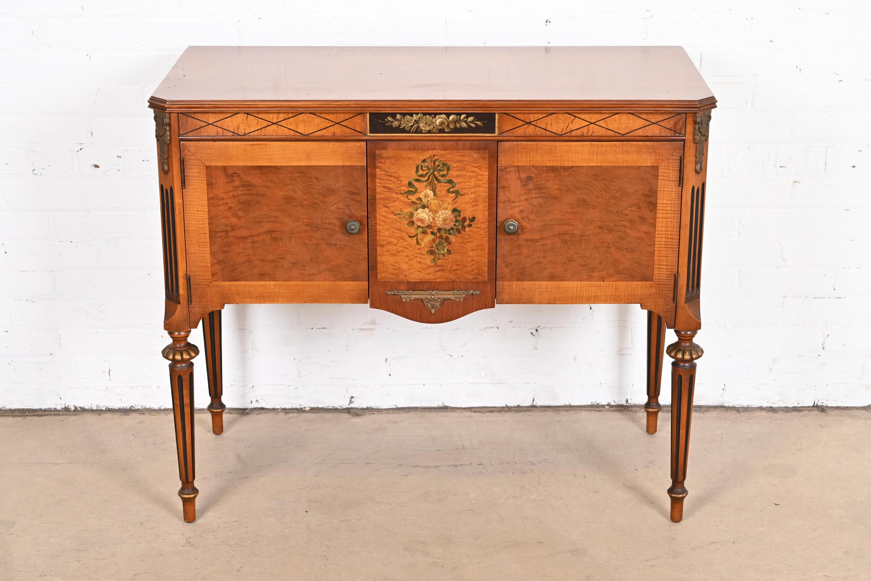 An exceptional French Regency Louis XVI style sideboard, buffet server, or bar cabinet

In the manner of Romweber

USA, Circa 1920s

Carved walnut, with inlaid satinwood, ebonized and gold gilt details, original brass hardware and mounted