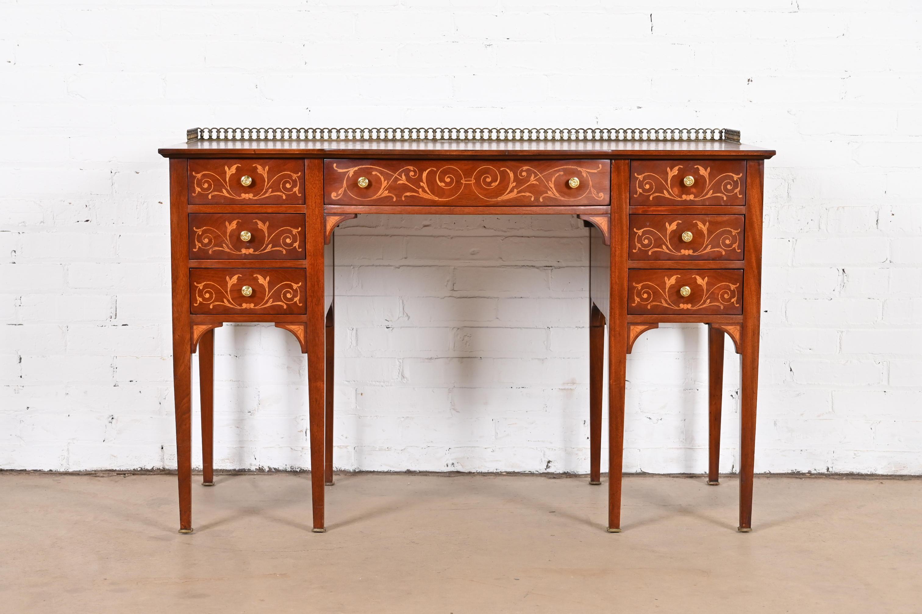 A gorgeous vintage French Regency Louis XVI style vanity or desk
By Johnson Furniture Co.
USA, circa 1930s
Mahogany, with beautiful satinwood inlaid floral marquetry, and original brass hardware and gallery.
Measures: 46