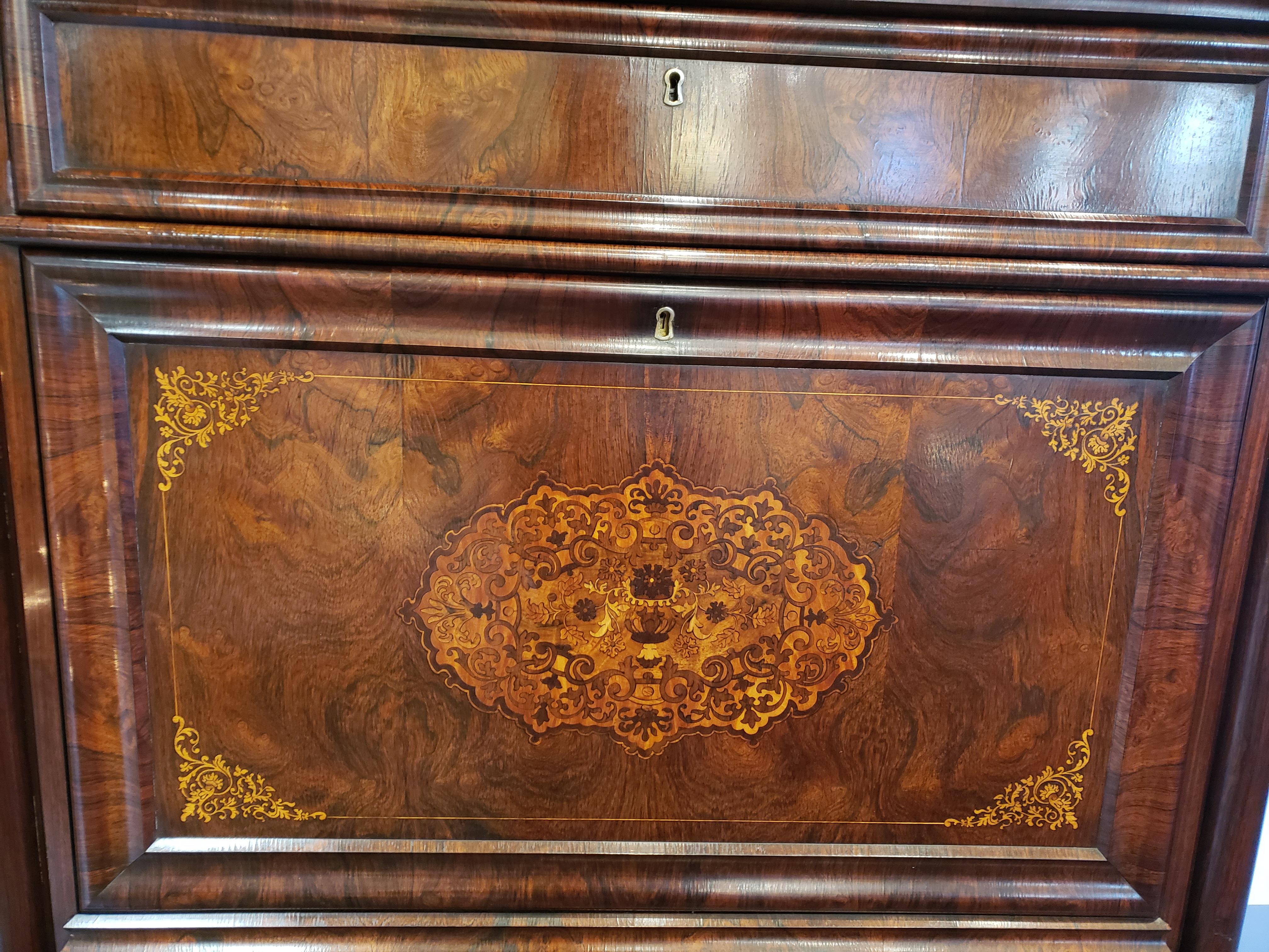 French Regency rosewood escritoire featuring satinwood interior drawers. This elegant piece consists of figural rosewood with mahogany and oak secondary woods. The center inlayed panel opens to display an elaborate interior with satinwood drawers,