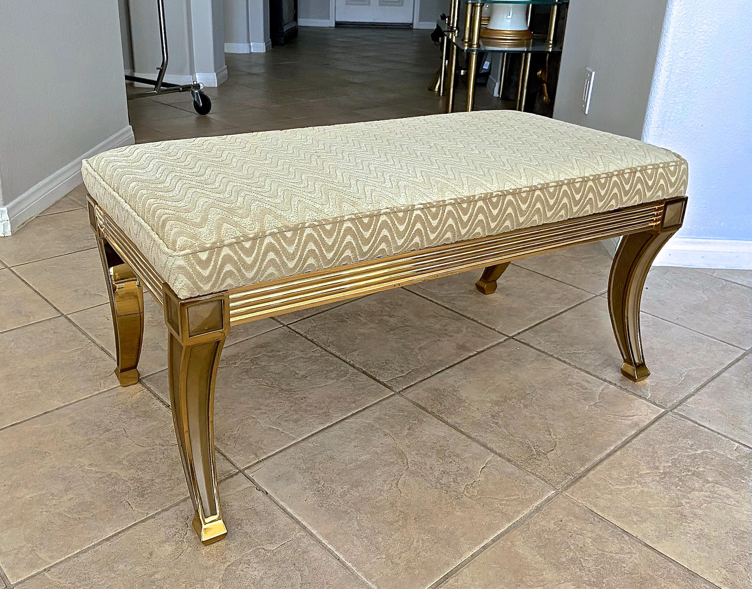 Regency style solid brass saber leg bench. The quality and detailing of the bench are extraordinary. Heavily constructed brass frame weighing over 60 pounds. Newly upholstered in cream zigzag pattern cut velvet fabric.