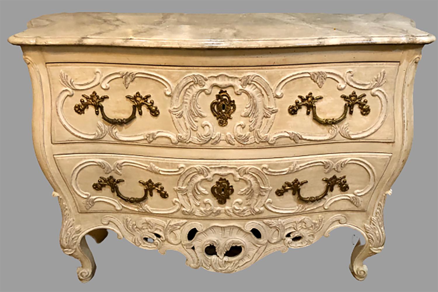 A faux marble top Regency style paint decorated two drawer commode by Maison Jansen. Nicely framed bombe sides sitting on a group of Louis XV legs supporting a Rococo carved and distressed finish commode. The interior all handcrafted cabinet maker