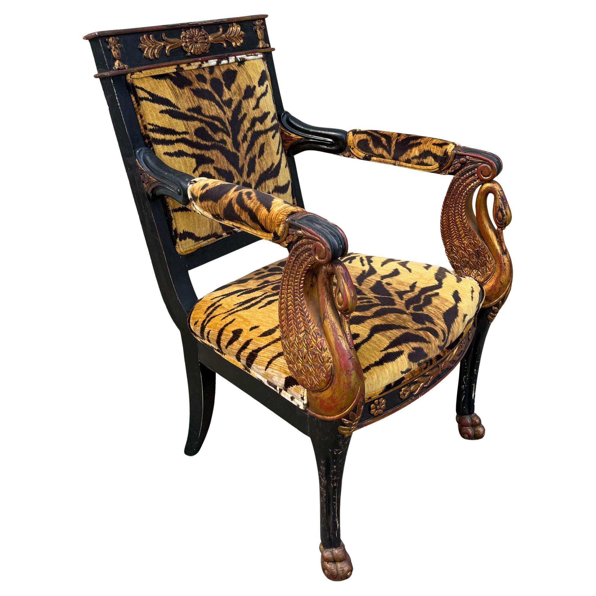 This is a killer chair! It is a regency style ebonized arm chair with neo-classical giltwood swan arms and paws. The tiger velvet is new. The chair is unmarked and is possibly by Patina. It has general wear to the finish that is likely to be