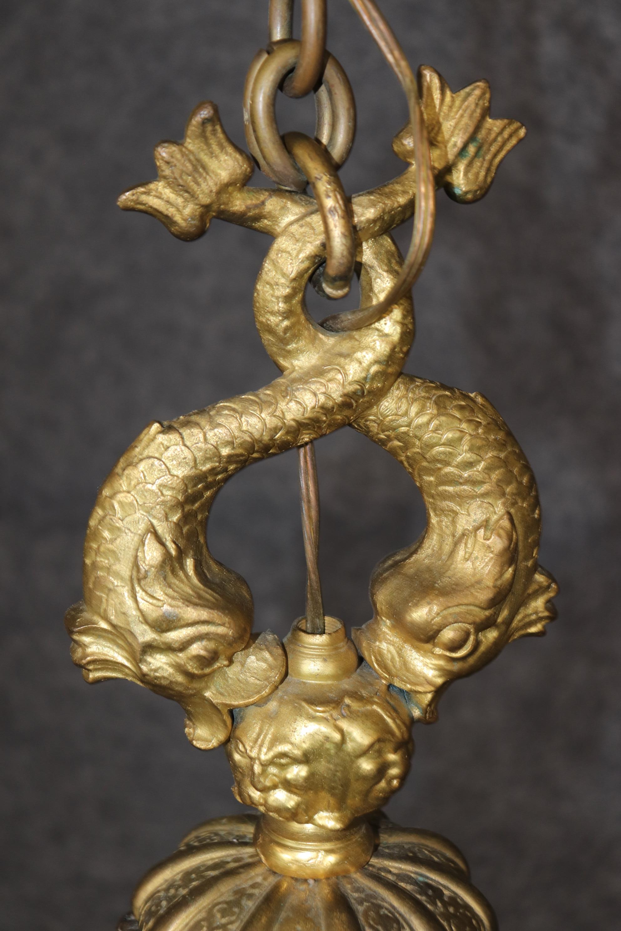 Si tratta di uno splendido lampadario in bronzo massiccio con patina bicolore e 6 luci, realizzato in uno stile insolito. Il lampadario raffigura mitiche maschere figurative di Bachus, volti grotteschi e un pesce a squame 