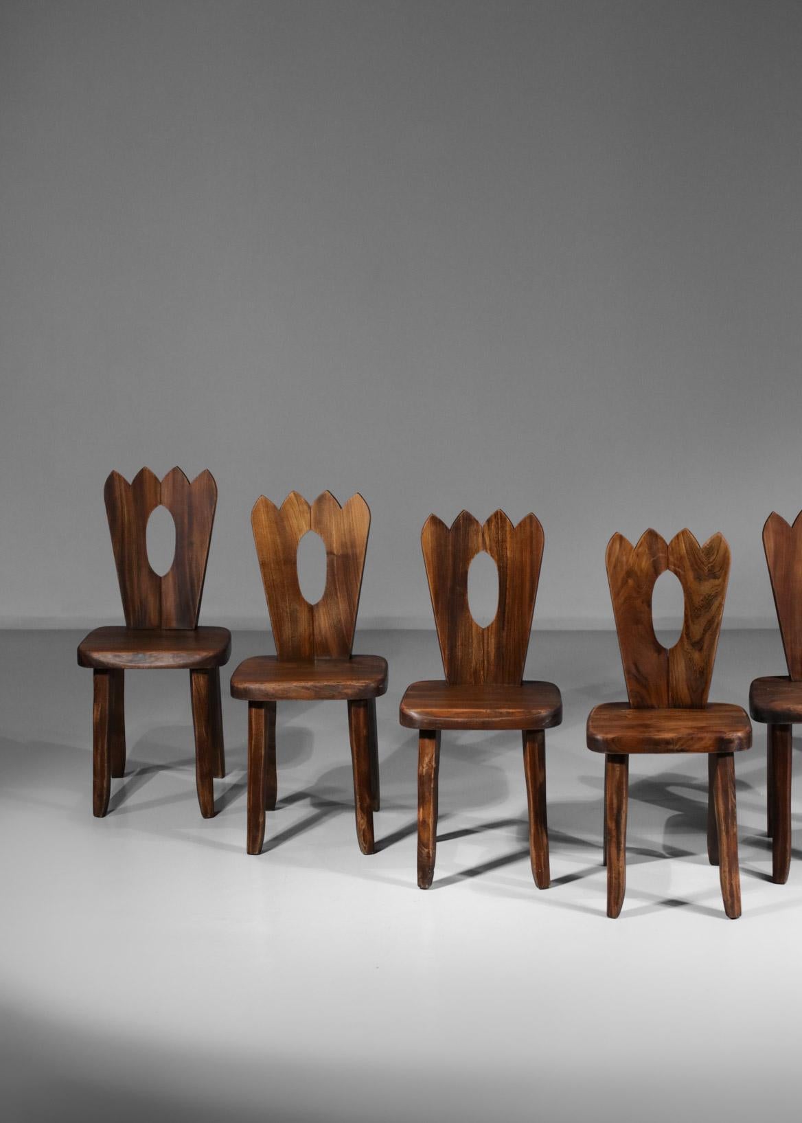 Set of seven French chairs from the 60's, French craftsmanship in style of Olavi Hänninen's work. Solid elm structure, carved backrest with decorative geometrical cut-outs, wood veins very well highlighted. Very nice vintage condition and beautiful