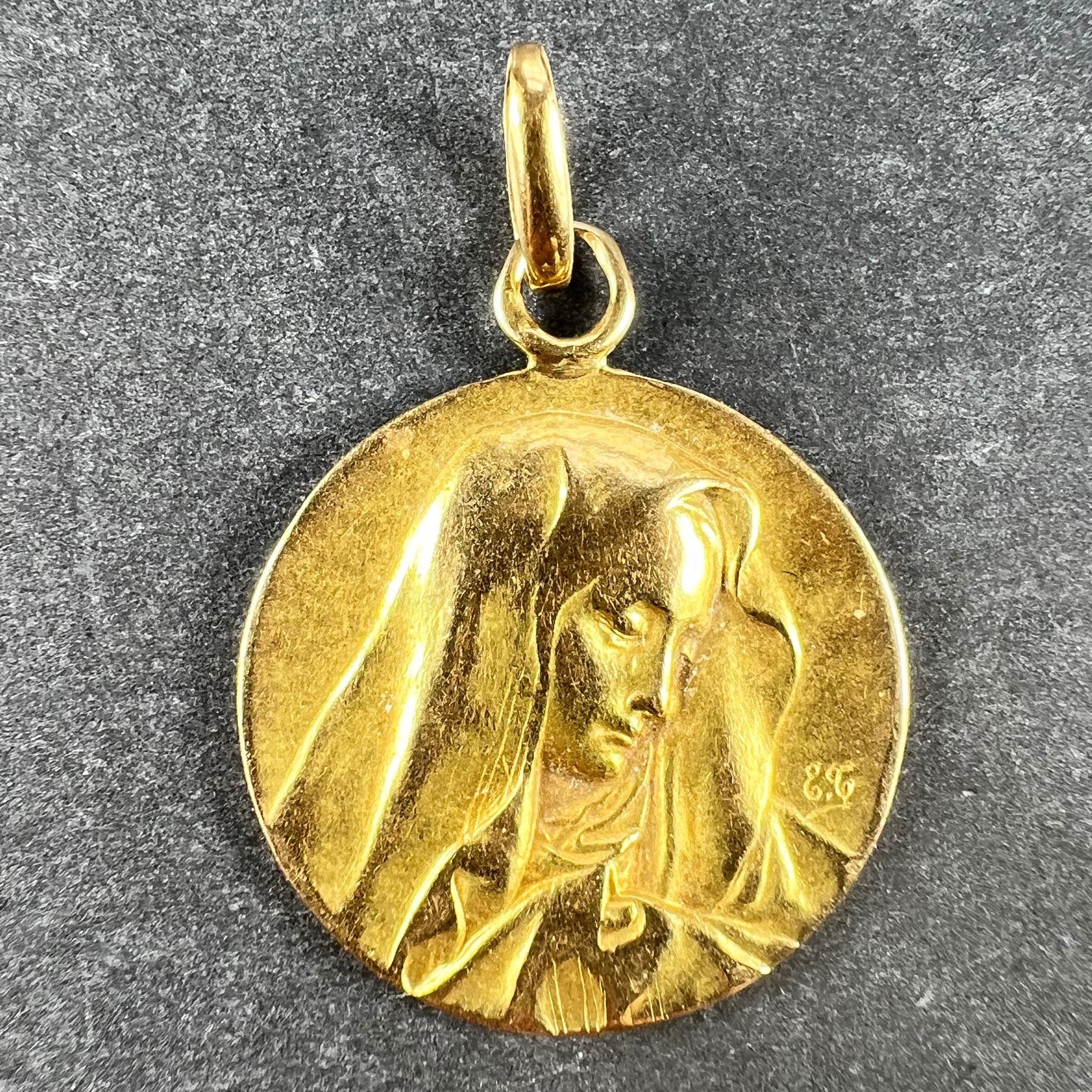 A French 18 karat (18K) yellow gold charm pendant designed as a round medal depicting the Virgin Mary in a veil; engraved Aline to the reverse and dated 26 Mars 1913. Unmarked but tested for 18 karat gold.

Dimensions: 2.1 x 1.8 x 0.13 cm (not