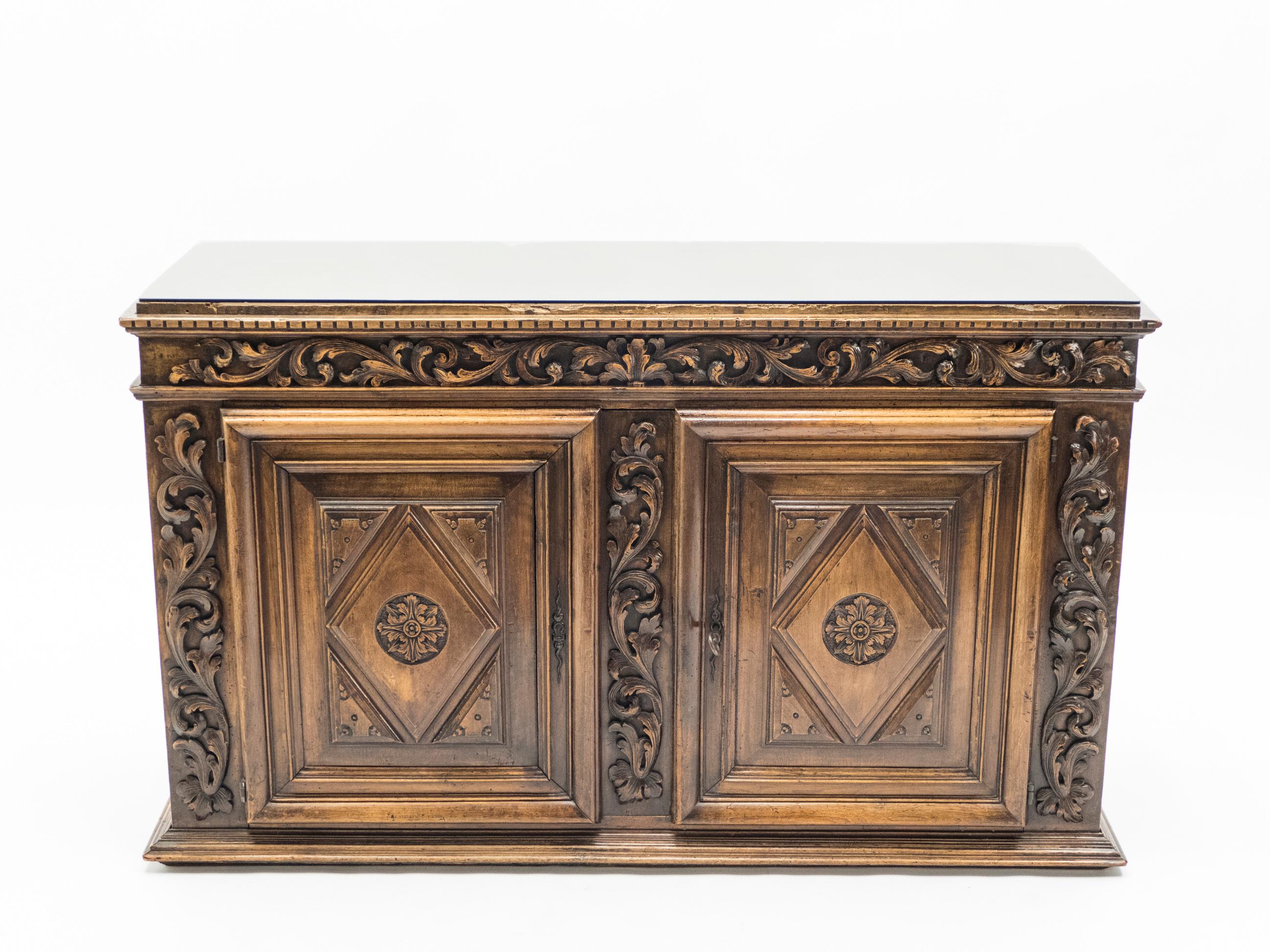 This piece is a brown oak French Renaissance sideboard that dates from the 1700s. It’s made from solid oak and the ornate designs have been painstakingly carved. It’s an extravagant antique piece with all the striking woodwork that French