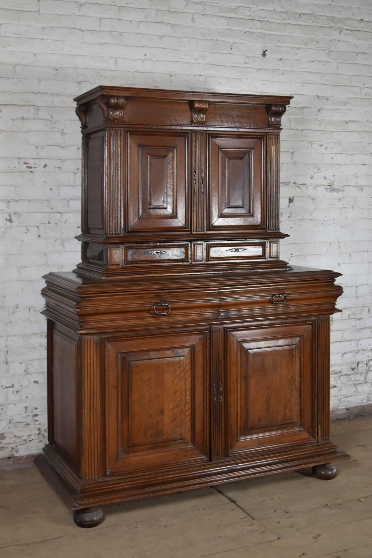 French Henry II Deux-Corps cabinet, in two parts. Of linear design and interesting, unusual proportions, the top part with two-doors over two drawers, bottom with two larger drawers over two-doors, supported by bun feet. Solid walnut construction