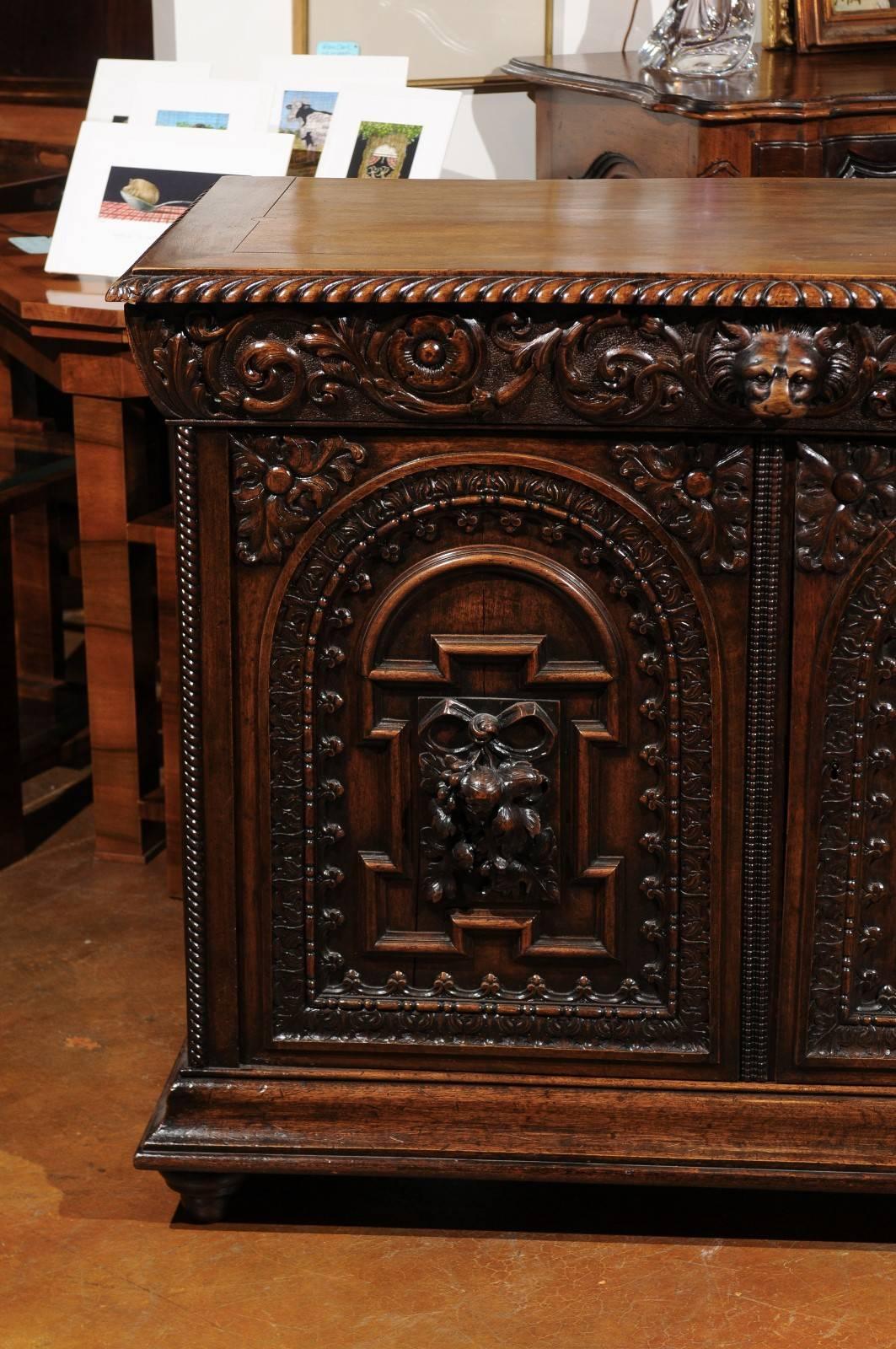 A French Renaissance Revival richly carved walnut two-door buffet from the mid-19th century. This French carved walnut buffet was born in the early years of the reign of Emperor Napoleon III, at a time when the Neo-Renaissance style was becoming