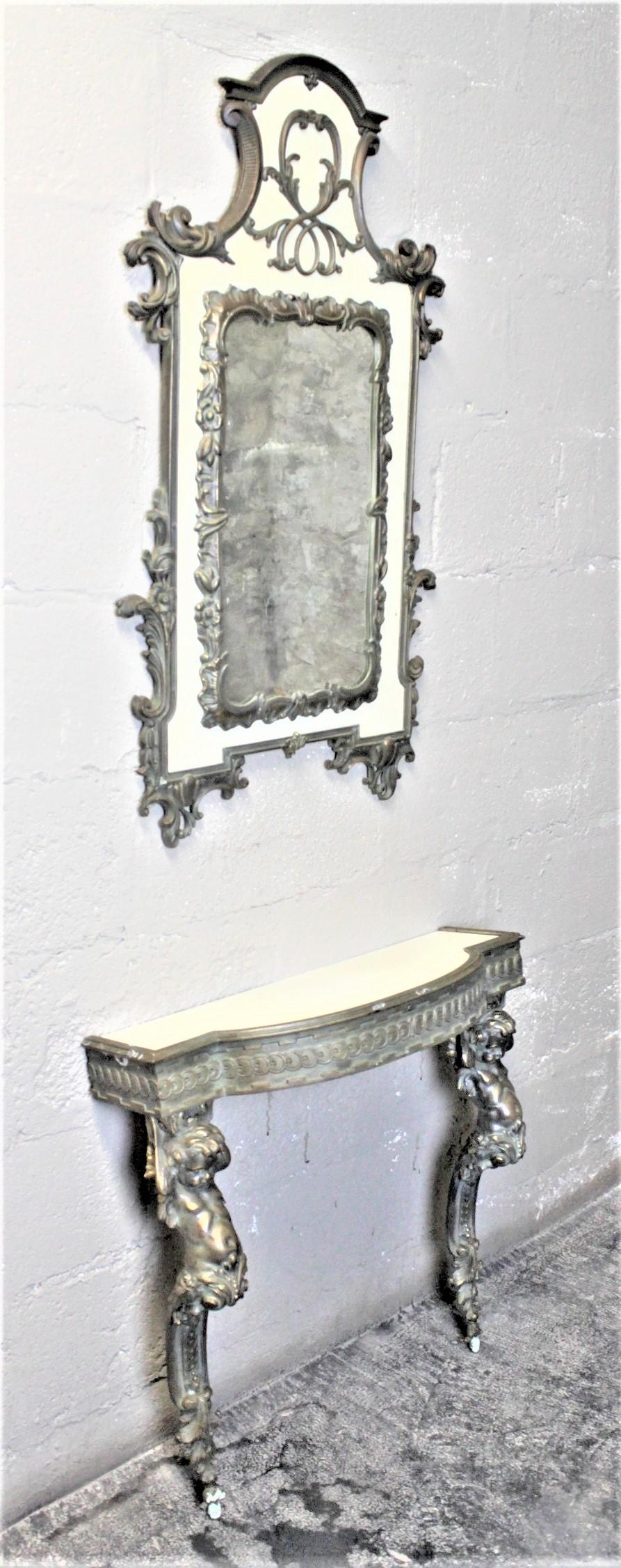 This vintage console table and mirror are unsigned, but presumed to have been made in the United States in circa 1955 in the French Renaissance Revival style. The base composition of both the table and mirror is thick plywood sheeting that have been
