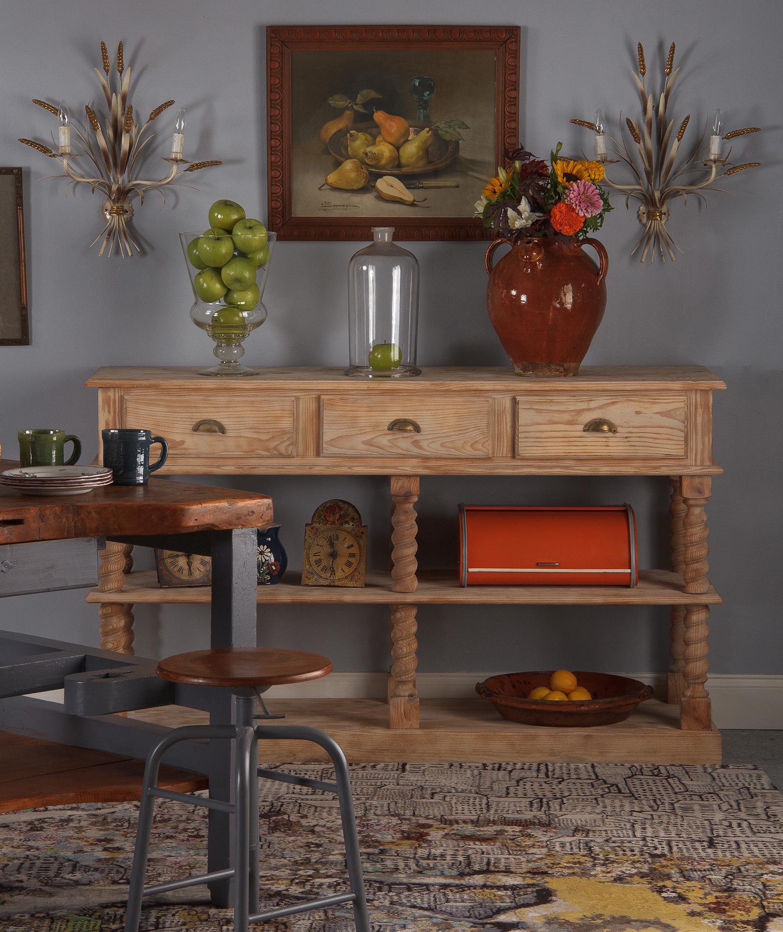 A large and attractive Renaissance Revival style stripped pine console desserte from France, circa 1920. All pine construction with aged brass hardware on each of the three shelves. Barley twist legs rest on a plinth base and support a centre shelf