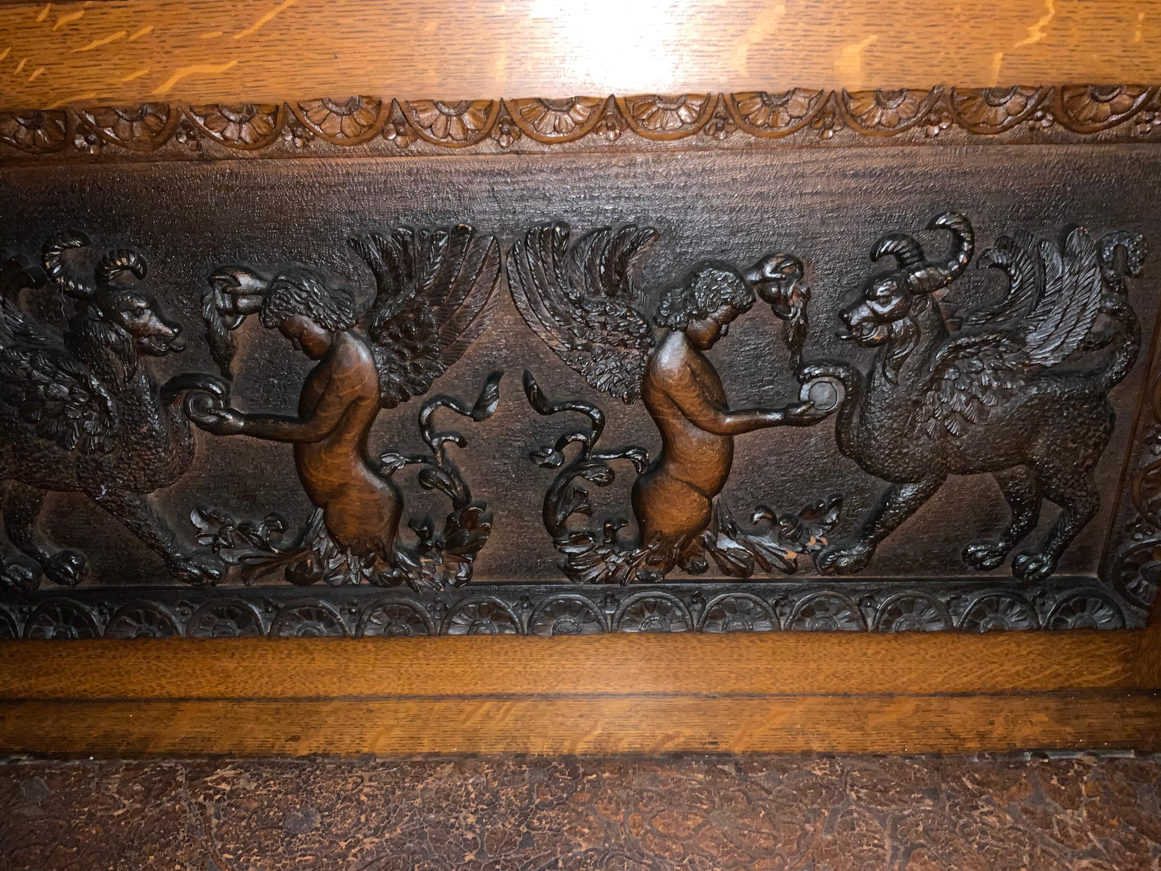 Handsome carved bench with superb carvings in oak. The arms are carved griffins with wings.
The seat is engraved leather that is original to the piece. The seat lifts up so the interior is great
For storage.