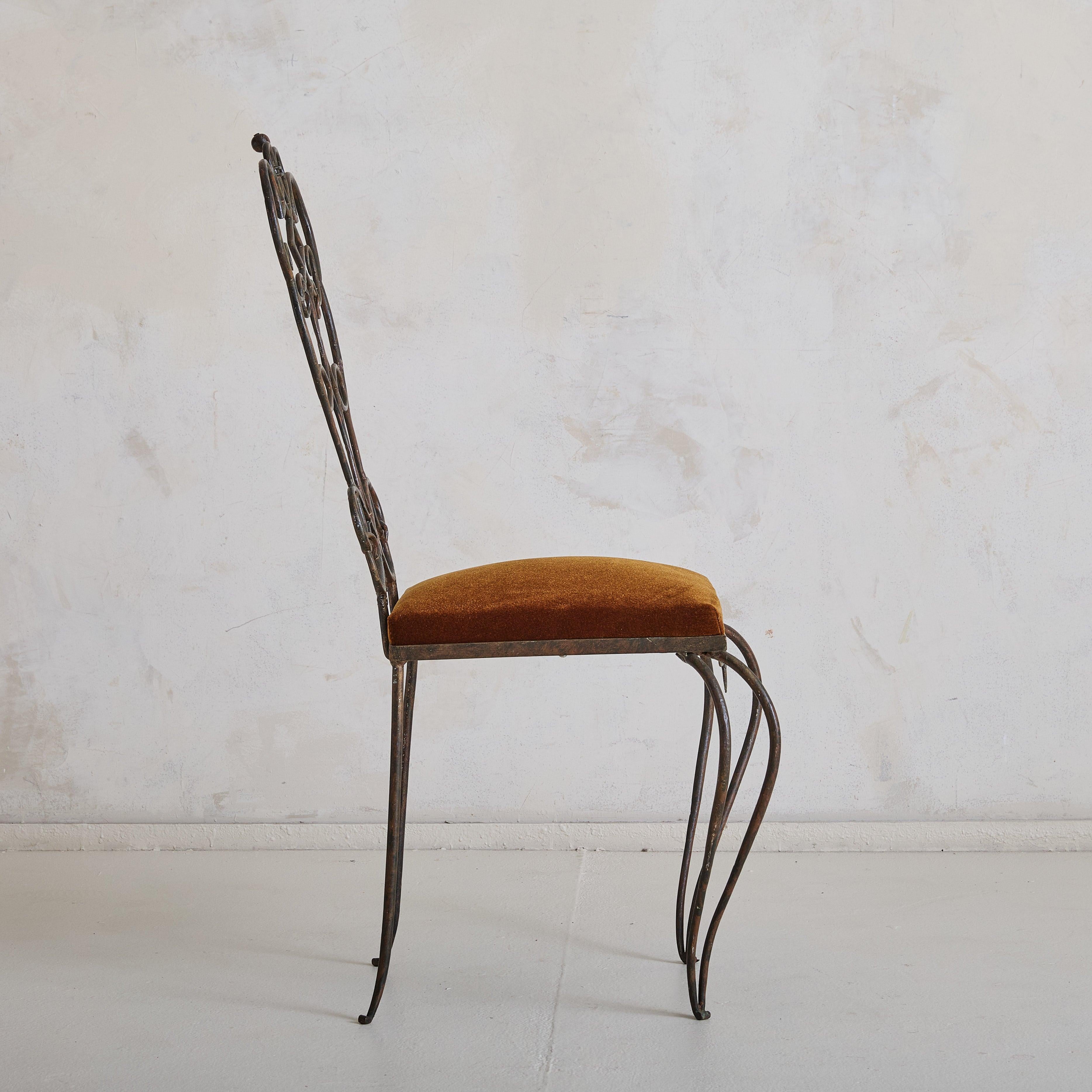 A 1930s French Art Deco accent chair, reflecting the honest designs of René Gabriel. Constructed from hand-forged wrought iron, the chair features an intricate backrest with flowing scrollwork and intertwined loops, complemented by gracefully curved