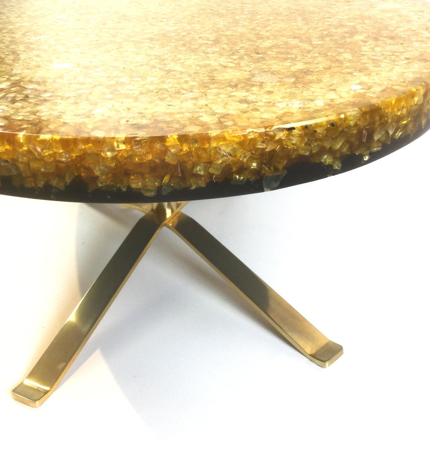 Ellipse coffee table by the biologist and plastician artist Pierre Giraudon 
The table is made from crackled resin with inclusions of broken glass supported by two brass-plated crossed legs

Pierre Giraudon was born in 1923. After a stay in