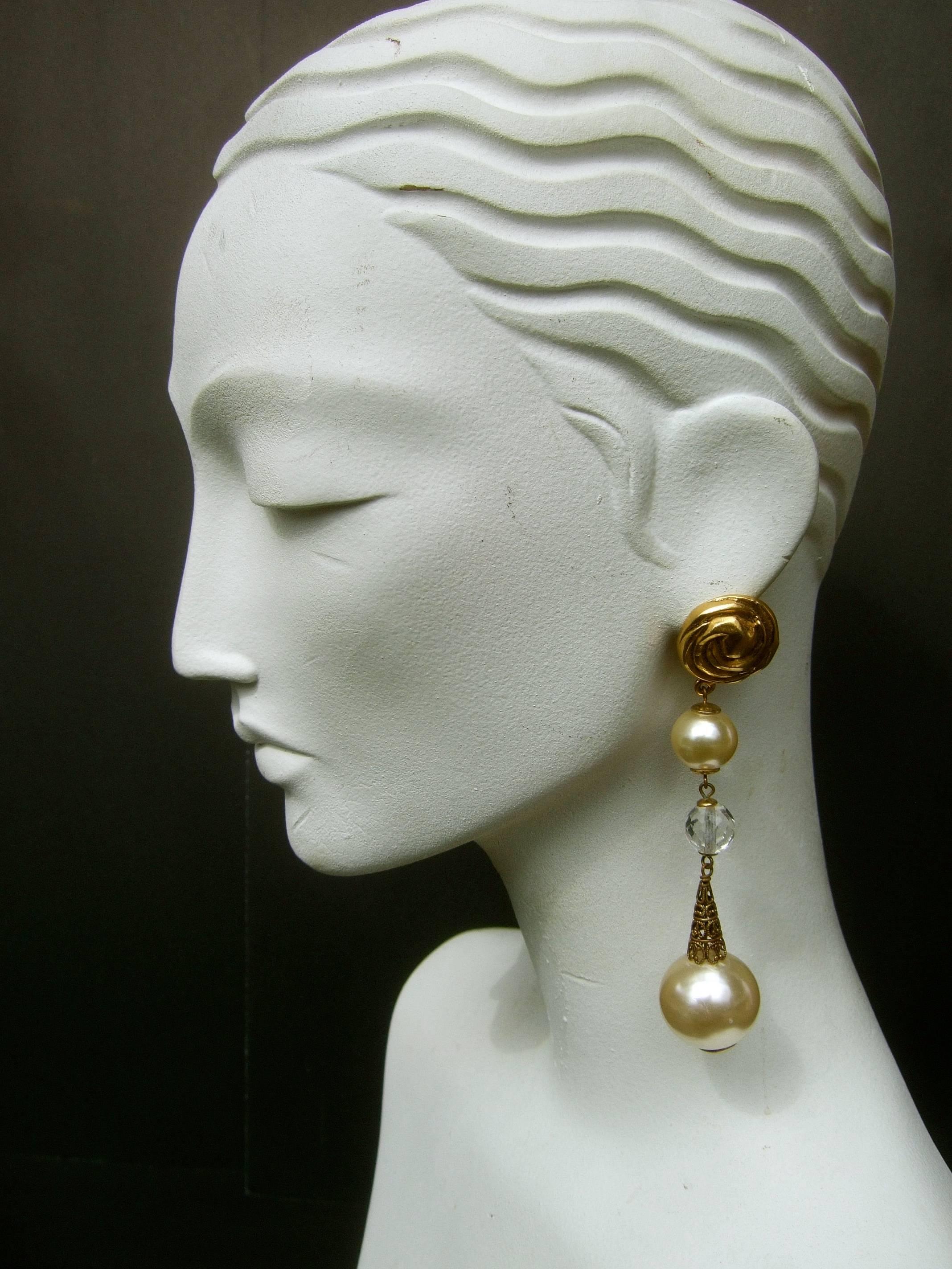 Opulent French resin pearl crystal statement earrings designed by Poggi Paris 
The long dramatic French earrings are designed with a large orb shaped 
resin enamel pearl dangling at the base

The gilt metal circular medallion clip at the top is