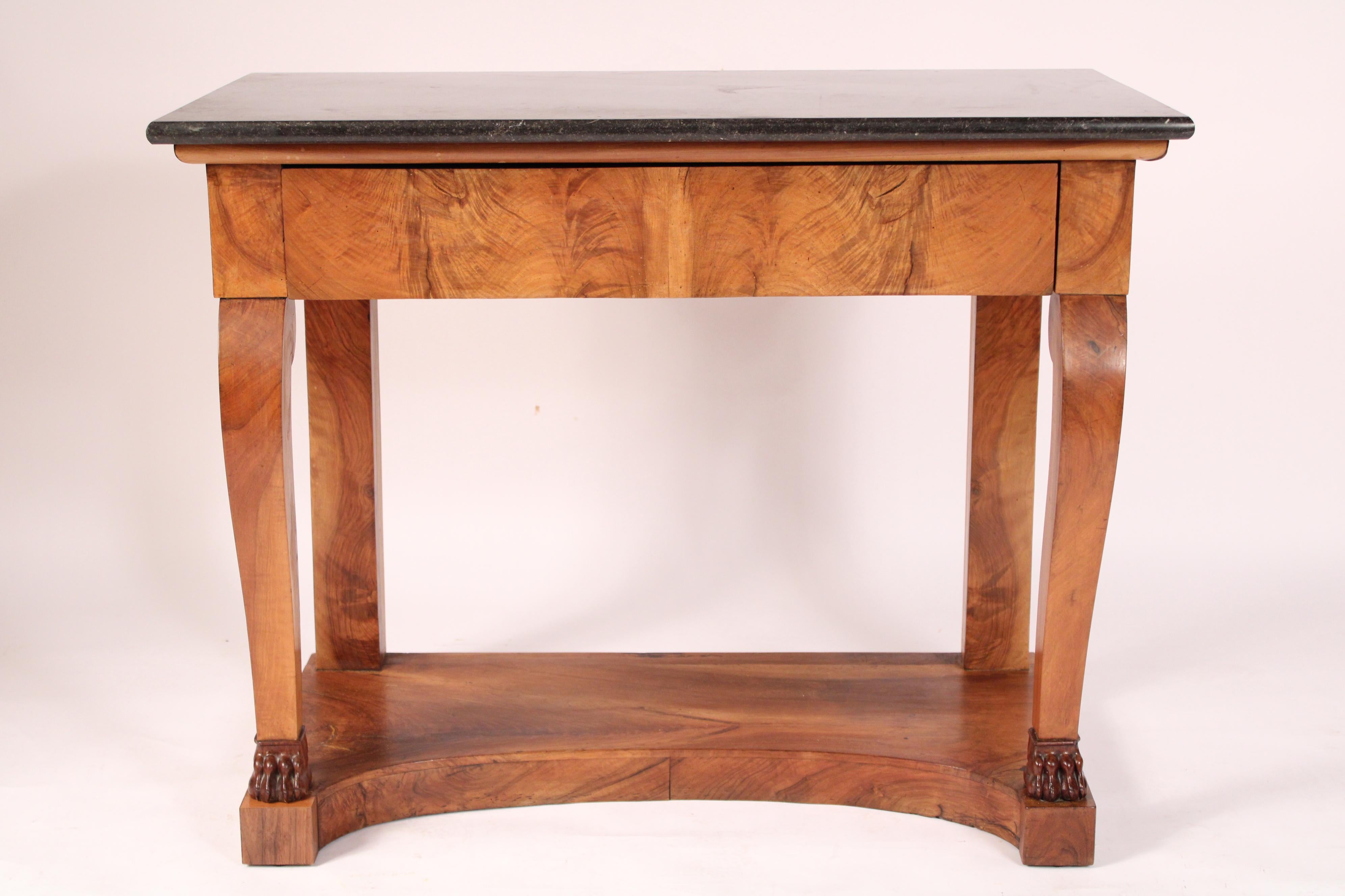 French restauration flame mahogany console table with marble top, circa 1830. Having a hand cut rectangular marble top, a flame mahogany frieze drawer, two scrolled front legs ending in paw feet, resting on an inverted platform base. Well figured