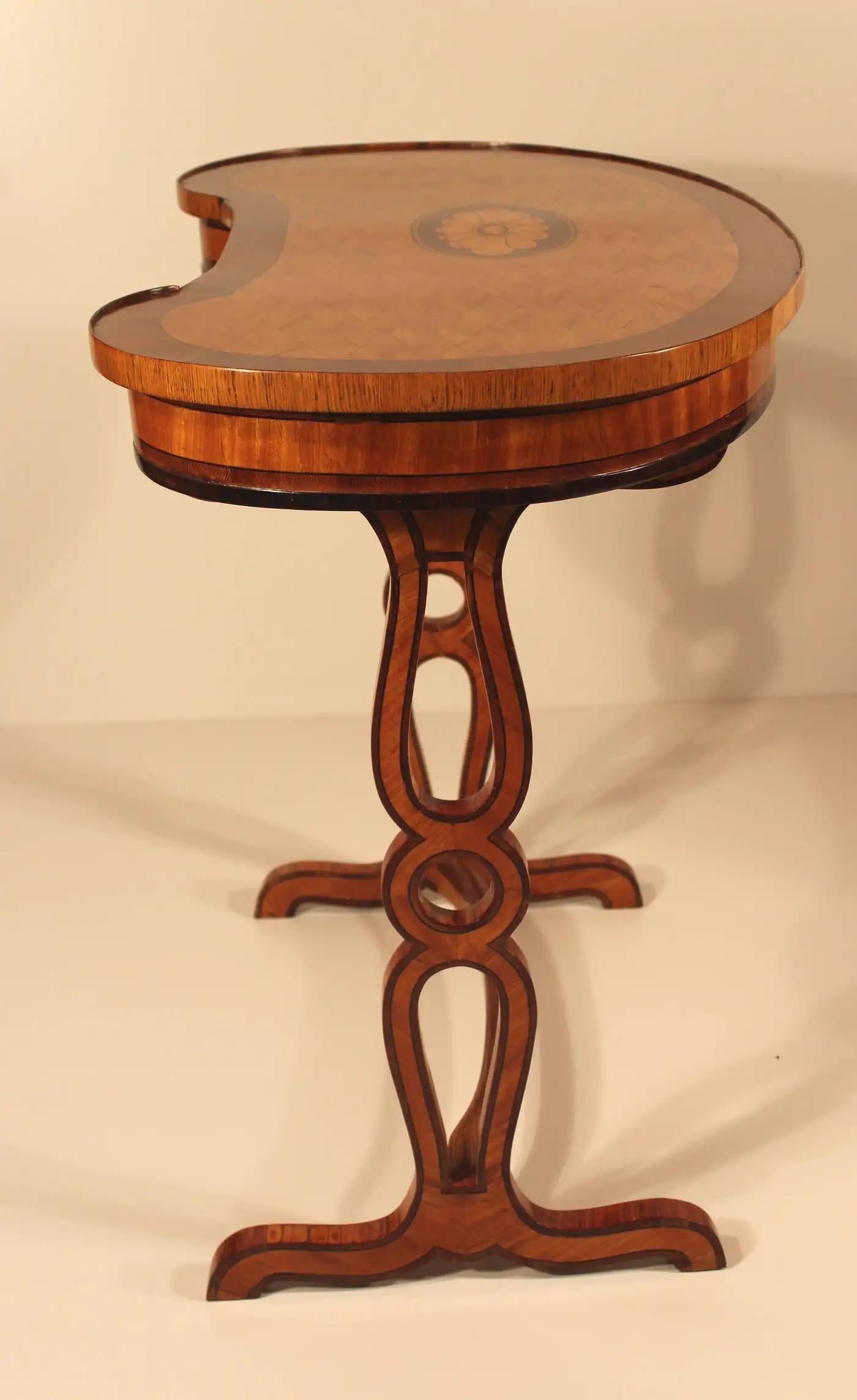 Cette étonnante table en forme de rein est un chef-d'œuvre d'artisanat, présentant un mélange harmonieux de placages de cerisier, d'acajou et de bois d'orme. Son design élégant et ses détails complexes en font une pièce remarquable pour tout