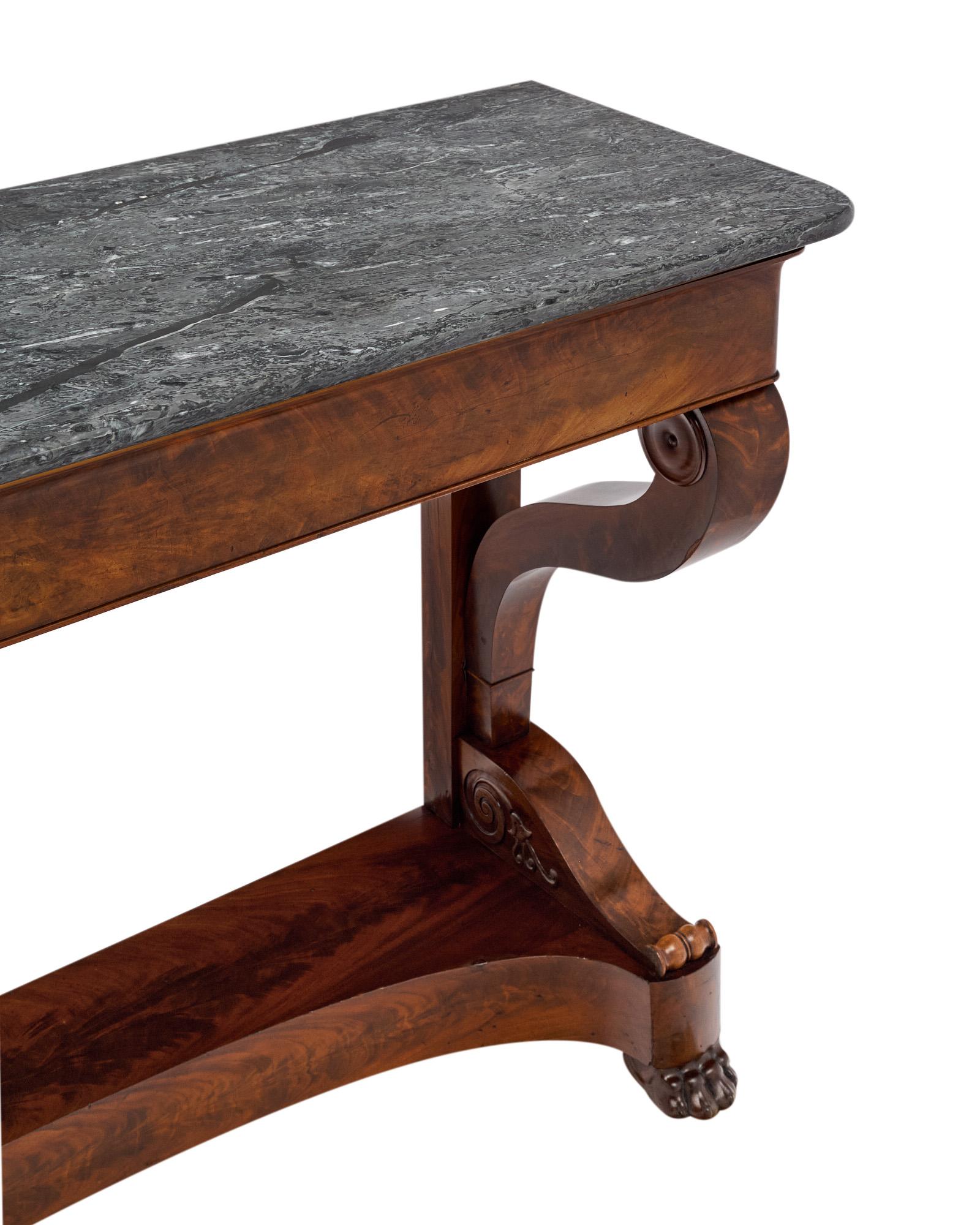 Fabriquée juste après la période de l'Empire français, cette console exquise est un exemple rare et frappant du design de l'époque de la Restauration. Fabriquée en France vers 1850, cette pièce est construite en acajou flammé cubain richement