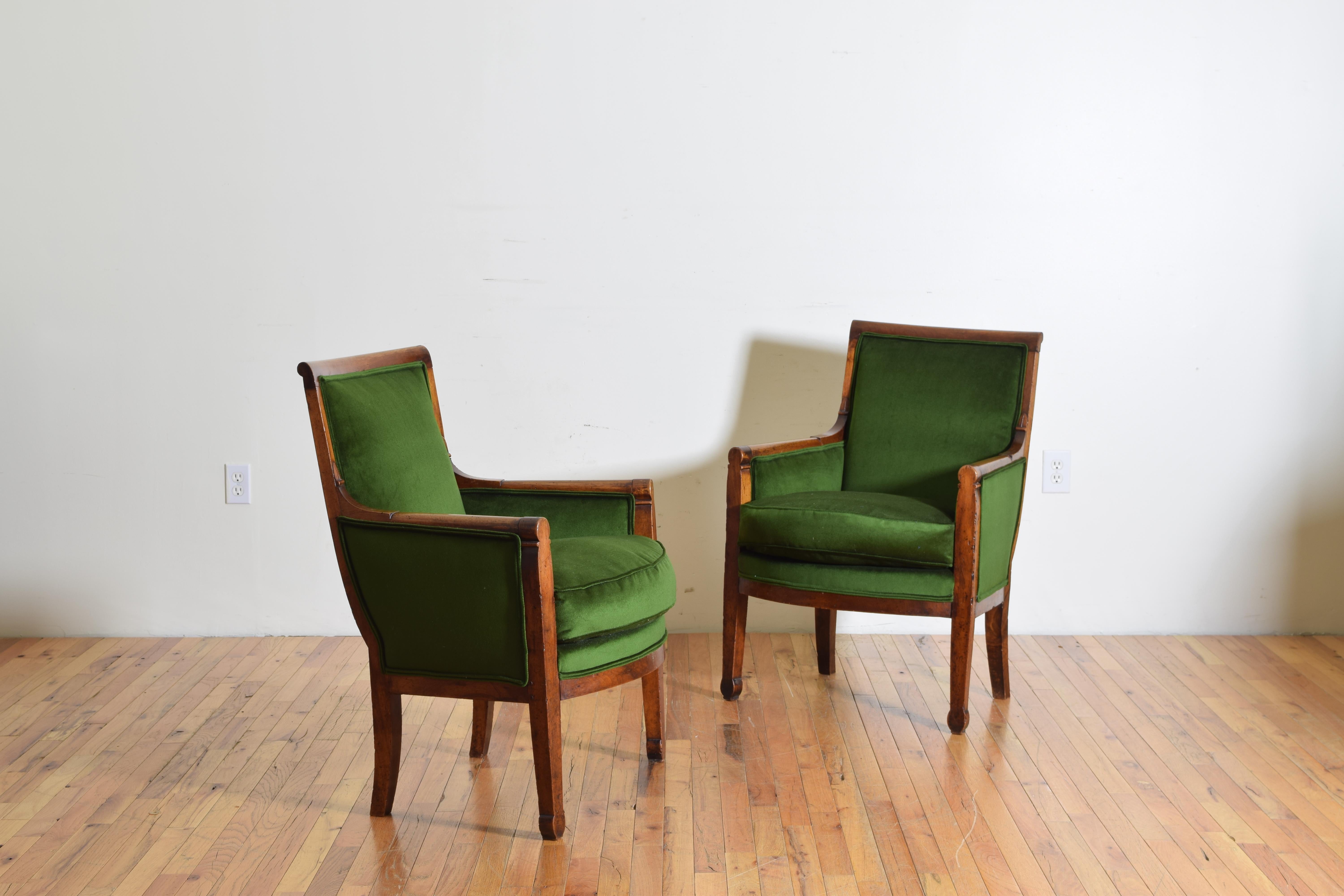 French restauration period pair of walnut and upholstered Bergeres, circa 1825. Upholstered in green velvet.