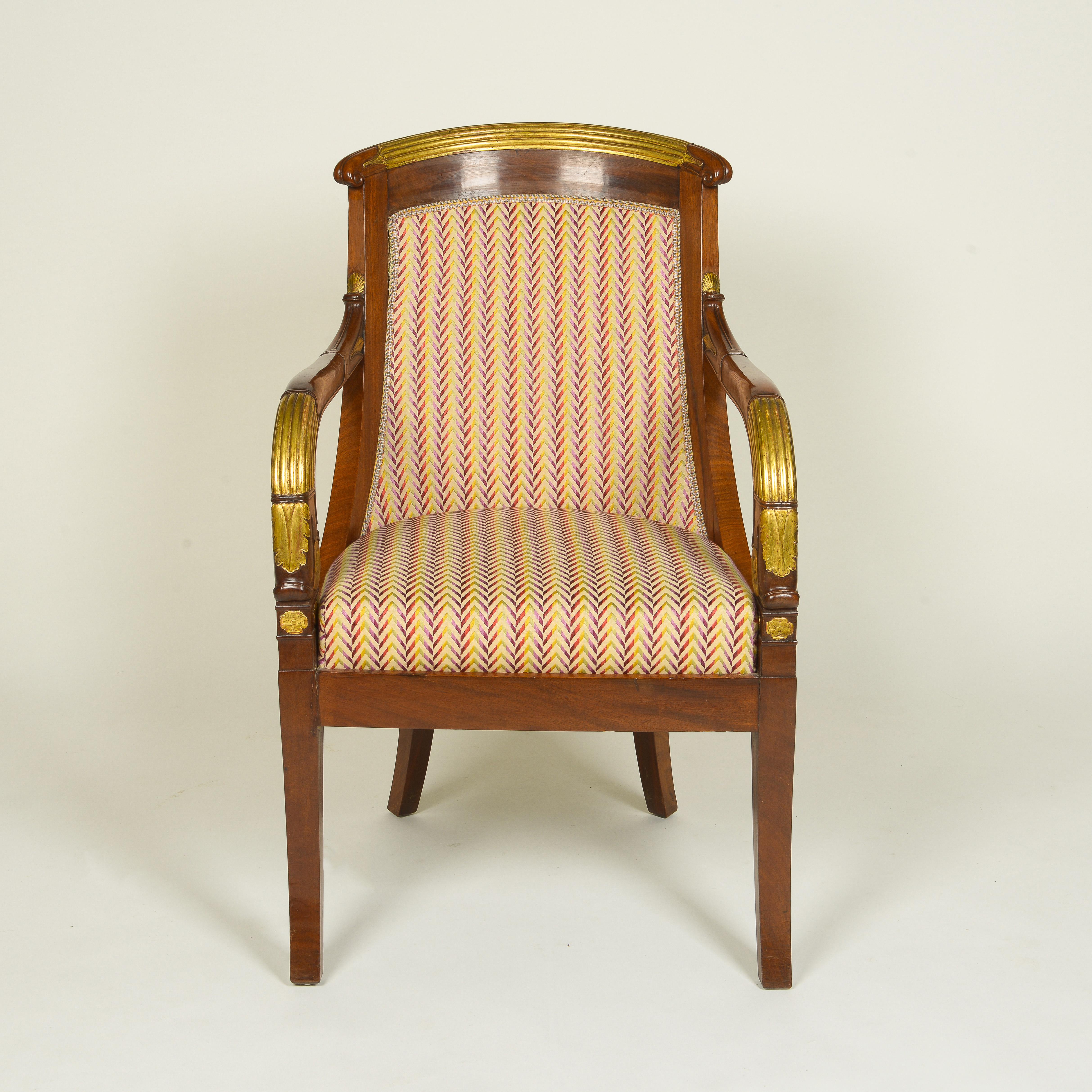 The tub-form padded back covered in a herringbone rainbow silk jacquard with reeded gilt crest rail terminating in scrolls and issuing two Downs-swept arms with gilt reeding and foliate embellishments; the upholstered seat over a deep seat rail on