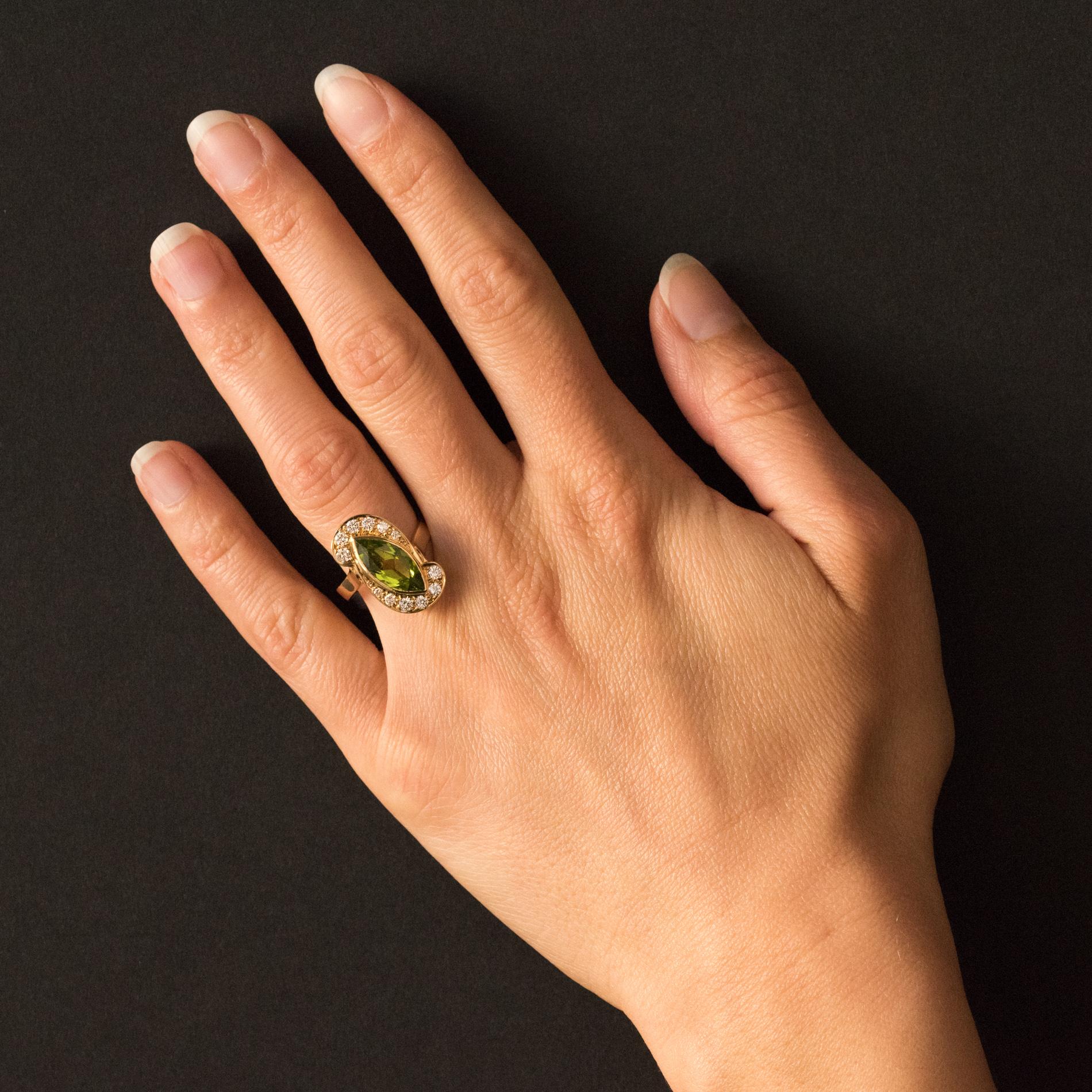 Ring in 18 karats yellow gold, eagle's head hallmark.
This astonishing retro ring features a sleek basket on which are set a shuttle- cut peridot surrounded by 12 brilliant-cut modern-grain diamonds. Geometric openings allow the light to penetrate