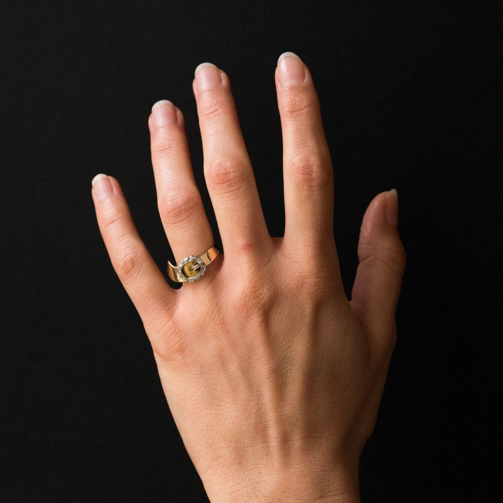 Ring aus 18 Karat Gelbgold, Adlerkopfpunze. 
Dieser Ring hat die Form eines Gürtels, bei dem die Nadel und die Schnalle mit Diamanten besetzt sind. 
Ein origineller und symbolträchtiger Ring, der das Thema Verbundenheit
