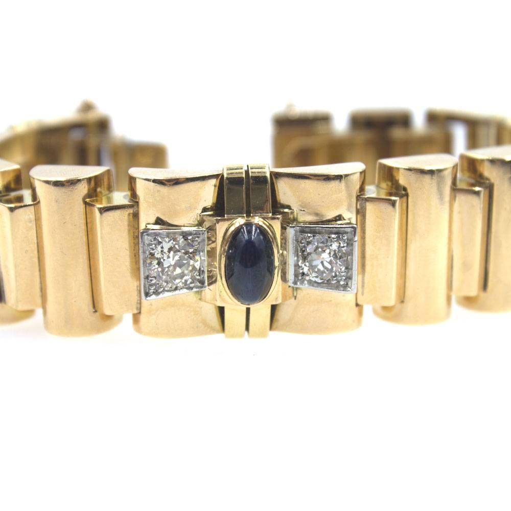 French diamond and sapphire link bracelet circa 1940's. This beautiful wide solid link bracelet is fashioned in 18 karat yellow gold. Six Old European Cut Diamonds and three cabochon sapphires are set throughout the bracelet. The bracelet measures