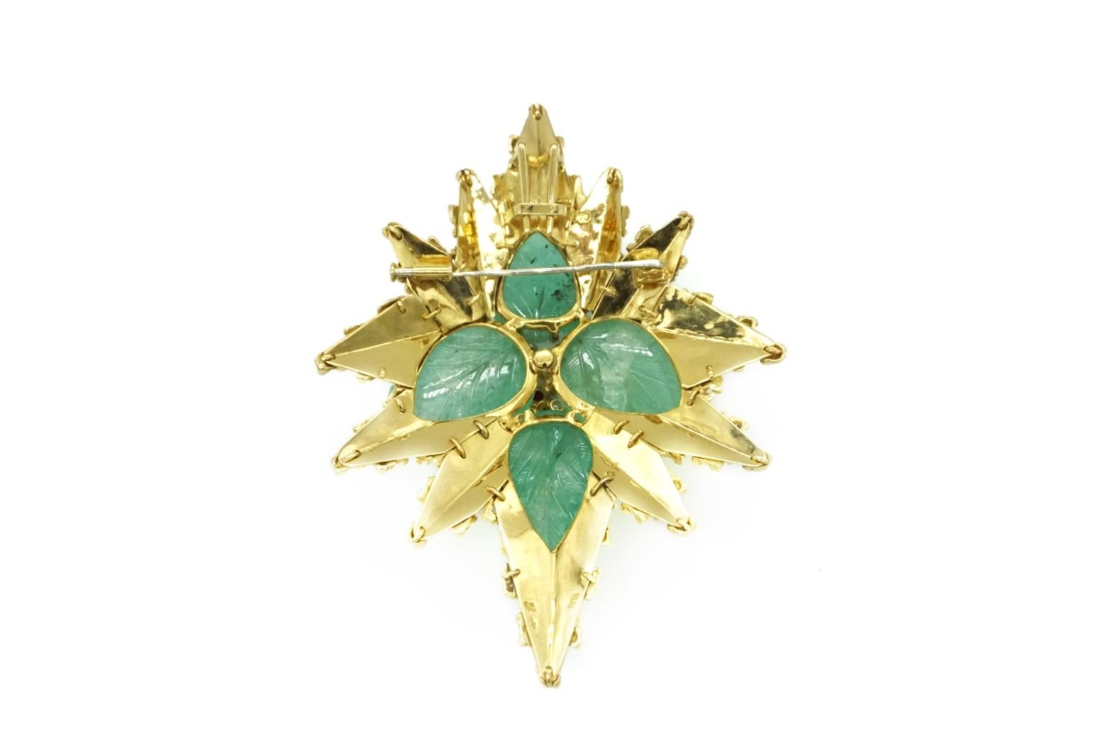 An exquisite Emerald, Diamond and Ruby Brooch/Pendant in 18k Yellow Gold 
Set with 4 Emeralds weighing app. 125.00 ct (leaves 7 Burma Rubies weighing app. 1.10ct and 13 Diamonds weighing app. 2.50 ct). Made in France, circa 1950.
F-G Color, VVS-VS
