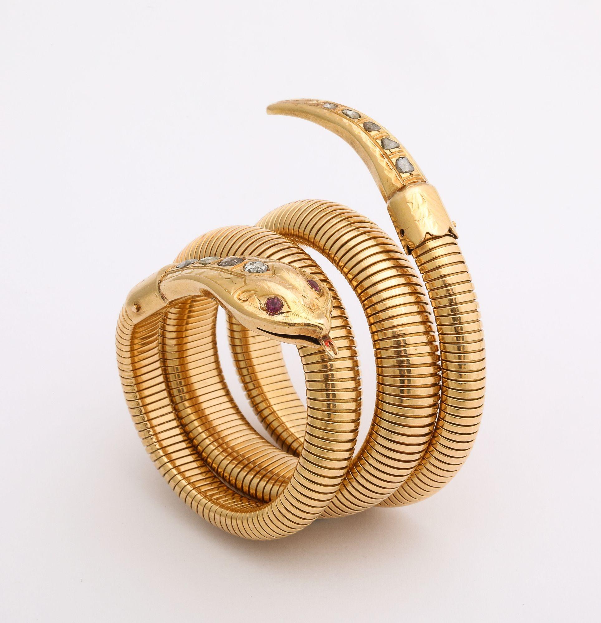 A stunning 18 Kt Gold snake bracelet with diamond accents both head and tail. Crafted in 18k yellow gold a gorgeous bracelet in the form of a serpent with a flexible body that wraps around the wrist, and a head and tail detailed with scales that are