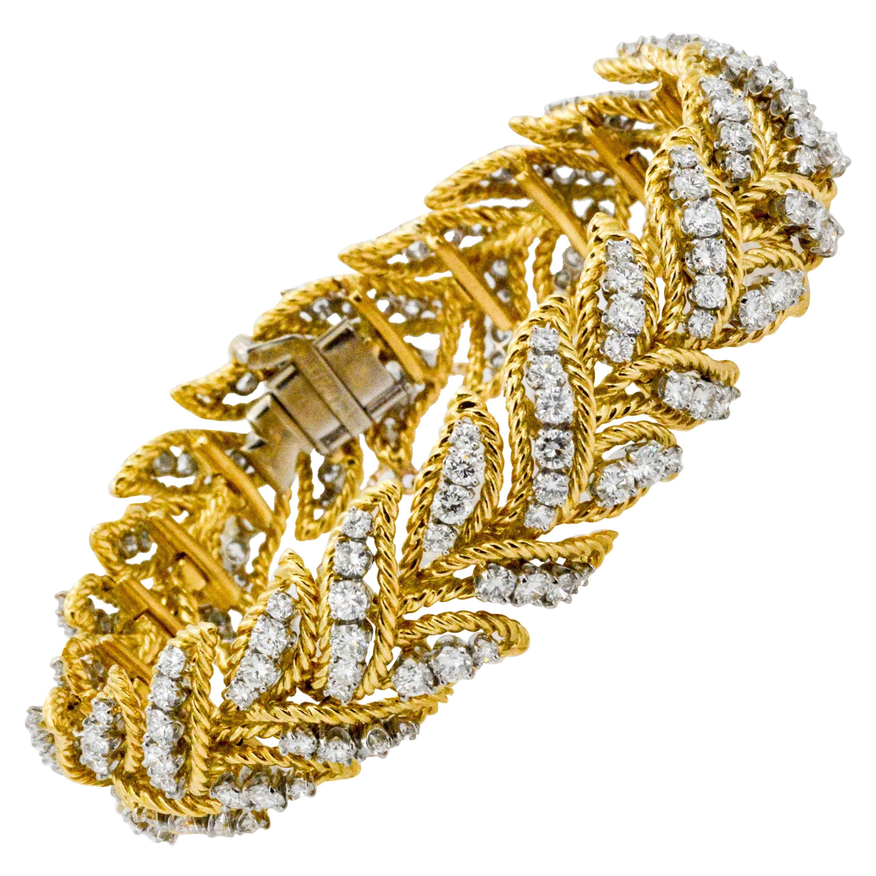 Created in France during the 1960's, this provocative retro, modern bracelet still has exquisite style. 18 Karat yellow gold ropes its way between and around 189 round diamonds (9.00 ctw). This leaf-look bracelet measures 7.5 inches in length, has a