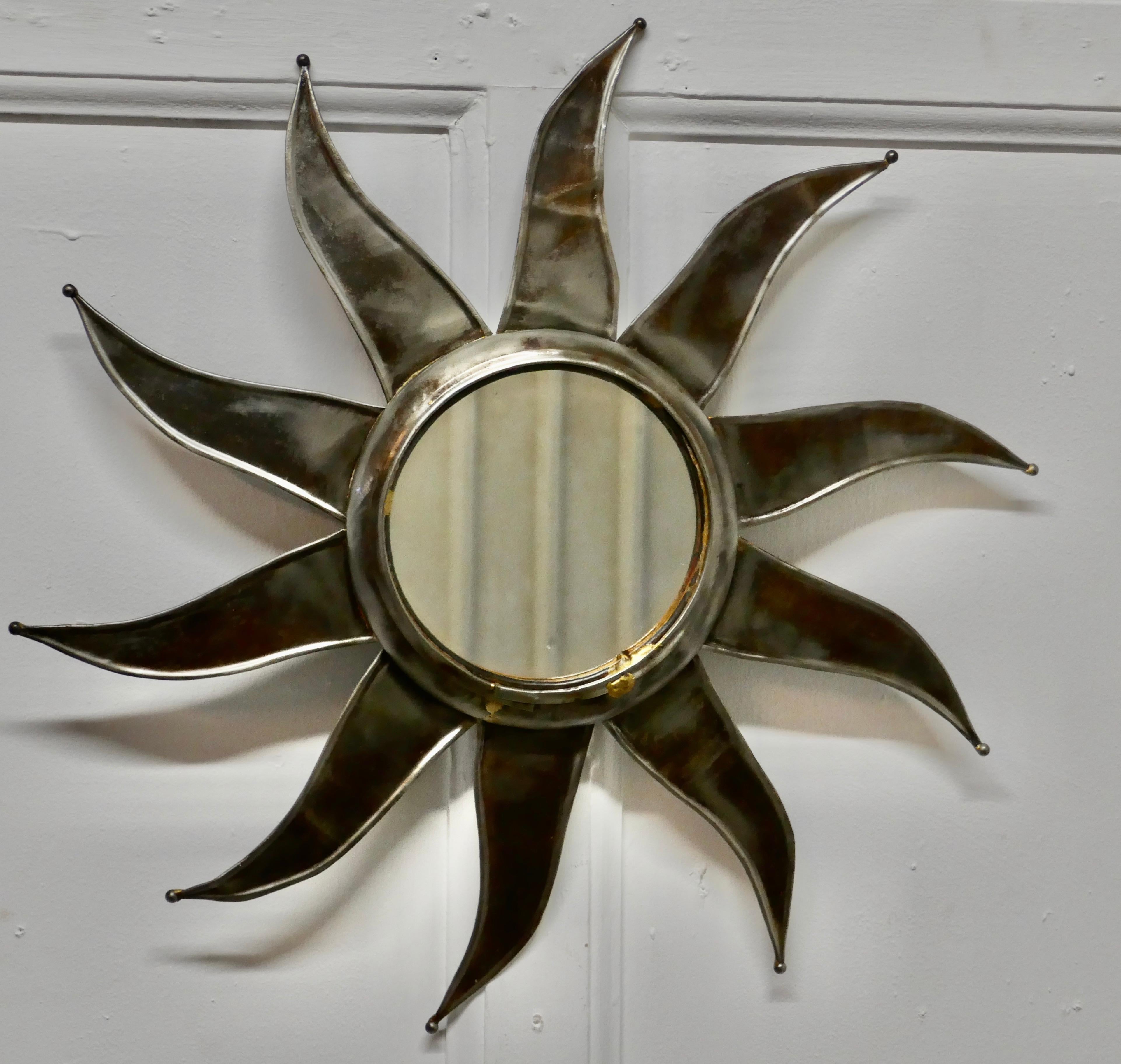 French retro sunburst industrial look polished steel mirror

A superb stylish piece, the starburst radiates out from the central mirror, the rays are slightly wavy in design, they take the form of large flat petals

A Classic from the 1960s era,