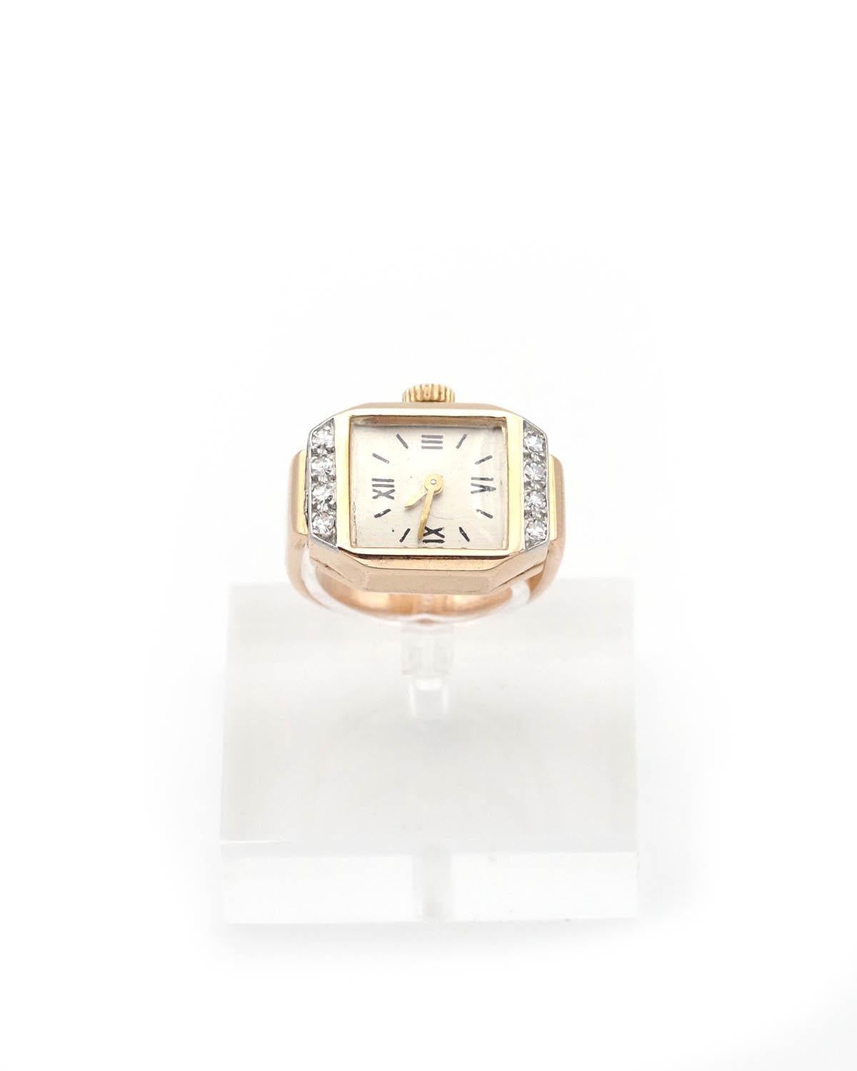 French Retro tank watch ring in 18 karat gold and diamond with an octagonal shape, centered on a rectangular watch case, framed by a line of 4 8/8-cut diamonds. The dial features black enameled Roman numerals on a light gold background, protected by