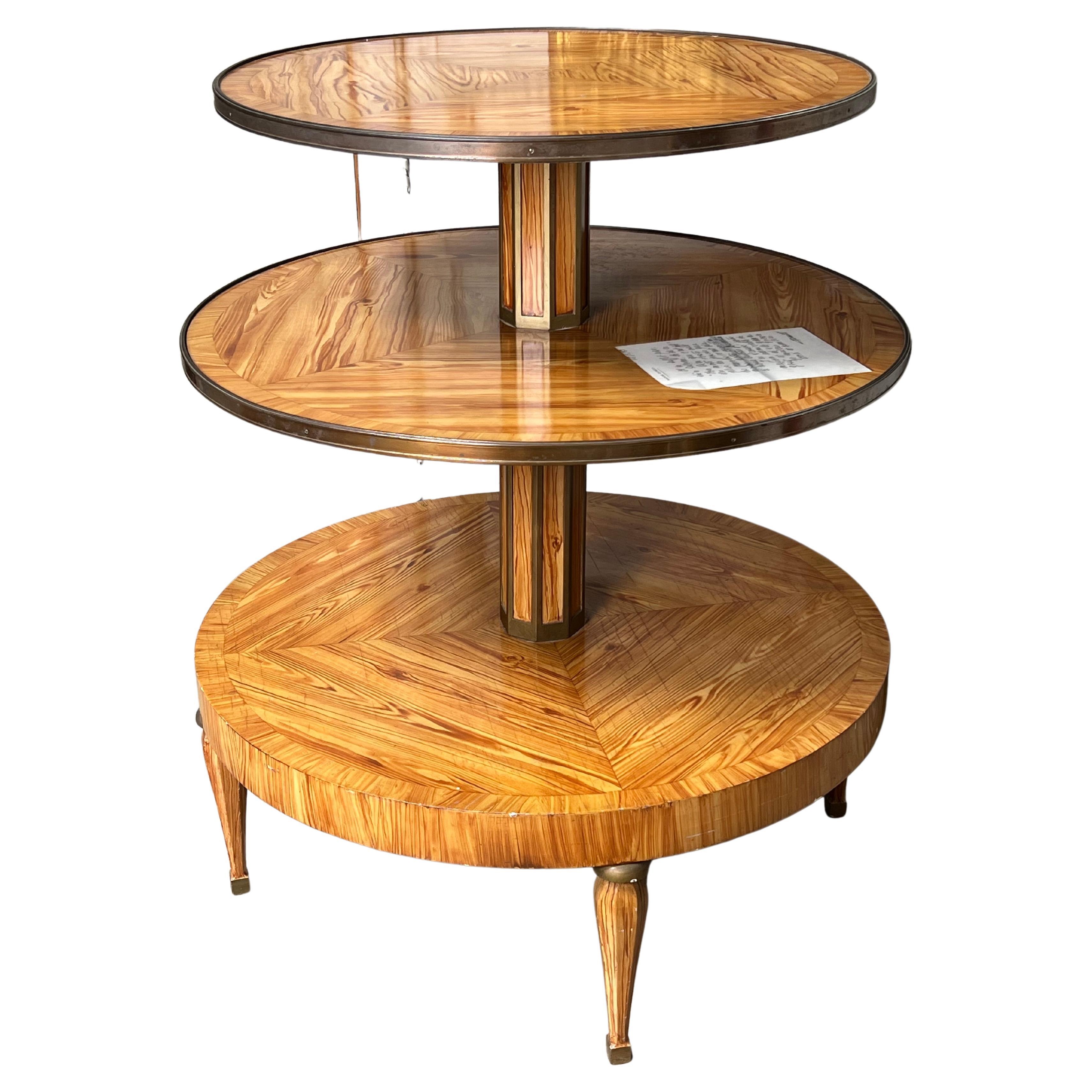 A French revolving dumb waiter, dessert table with a painted wood finish and bronze fittings. An applied letter in French on second shelf stating the quality of the table. this Faux bois three tiered table could also serve as an etagere for