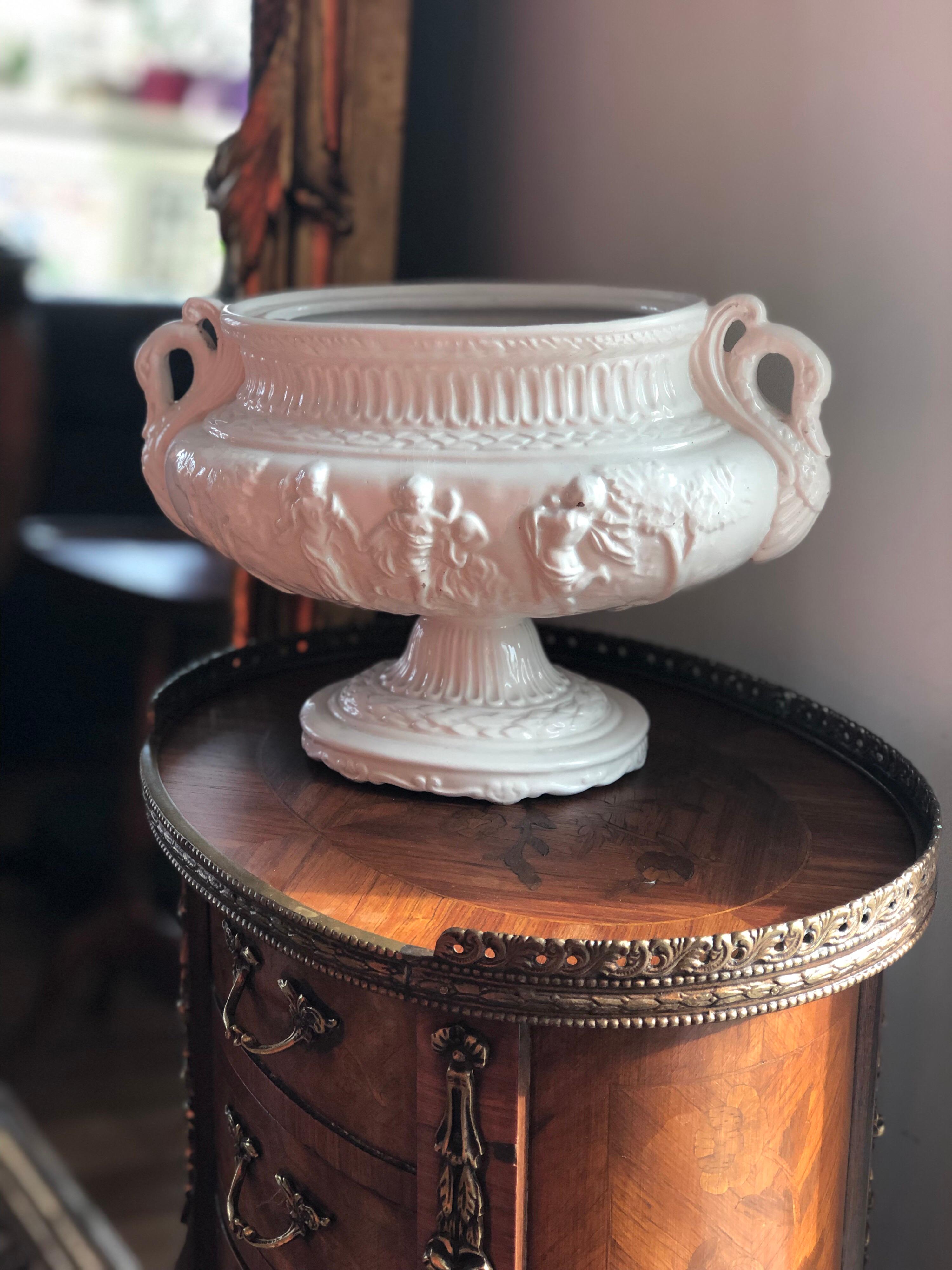 Beautiful asymmetric porcelain centrepiece decorated with cupids and swan heads at both sides raised on a single oval platform.
    