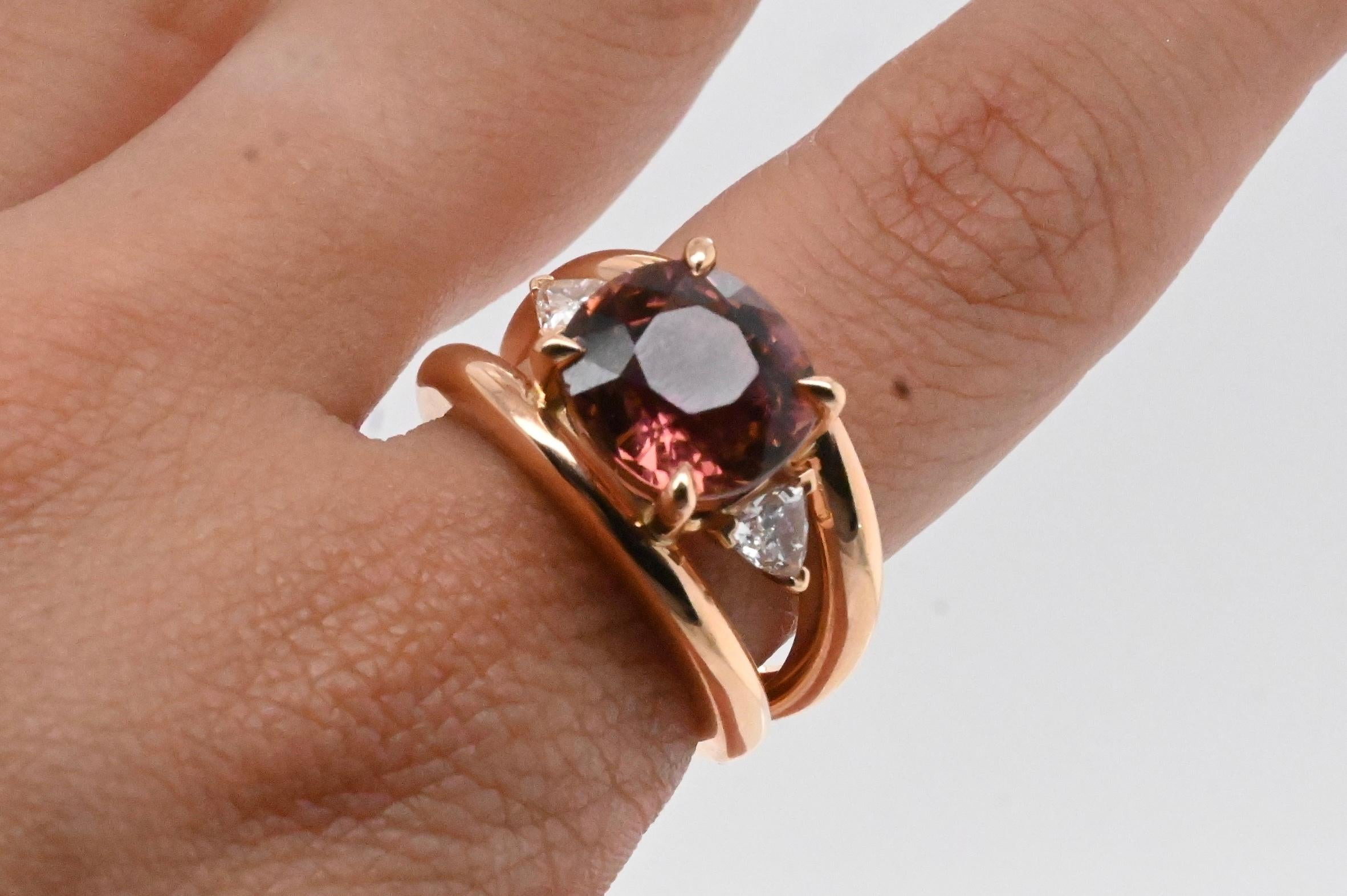Ring in 18 Carat Pink Gold Topped with a Pink Tourmaline and 2 Diamonds Troïda
Ring in 18-carat pink gold topped with a cushion-shaped pink tourmaline.
Accompagned with 2 (Troïda) triangular-shaped G-color diamonds color G 0.43 carats.
The claws