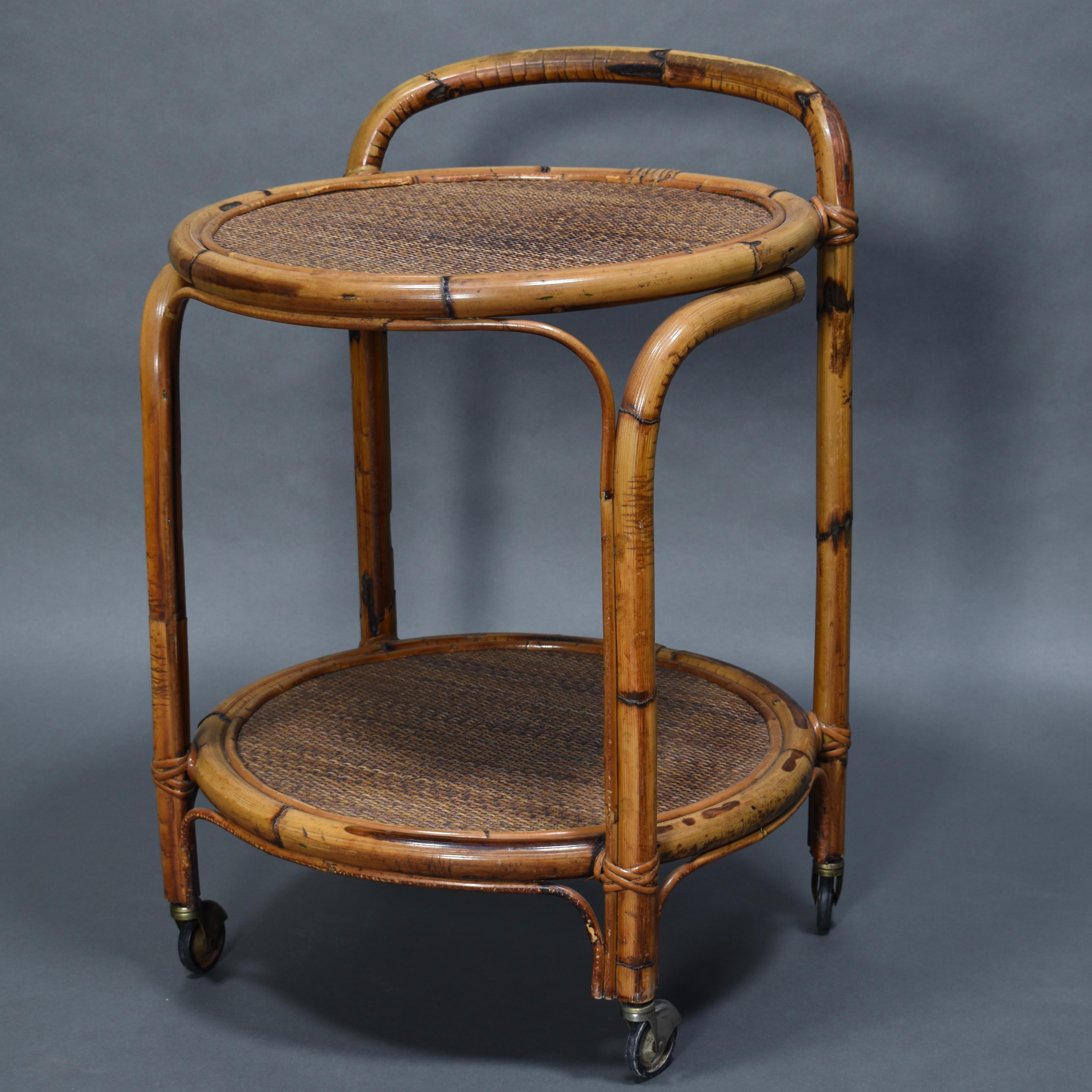 French 'Riviera’ bar cart made of Bamboo and Rattan, circa 1960.

Designer: Unknown

Manufacturer: Unknown

Country: France

Model: bar cart / serving trolley

Material: Bamboo / Rattan / Metal

Period: 1960s

Size: W x D x H 57ø x 76