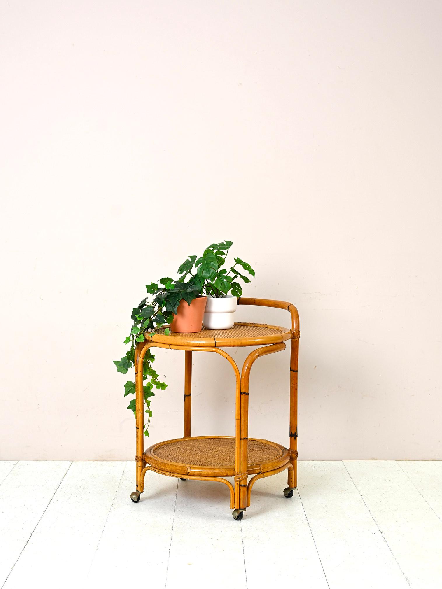 Original vintage 1960s trolley of French manufacture.

Elegant design trolley with retro charm. Consists of two round rattan table tops and a bamboo frame.
It can be used as a bar cabinet, as a side table, to embellish the veranda or terrace, but