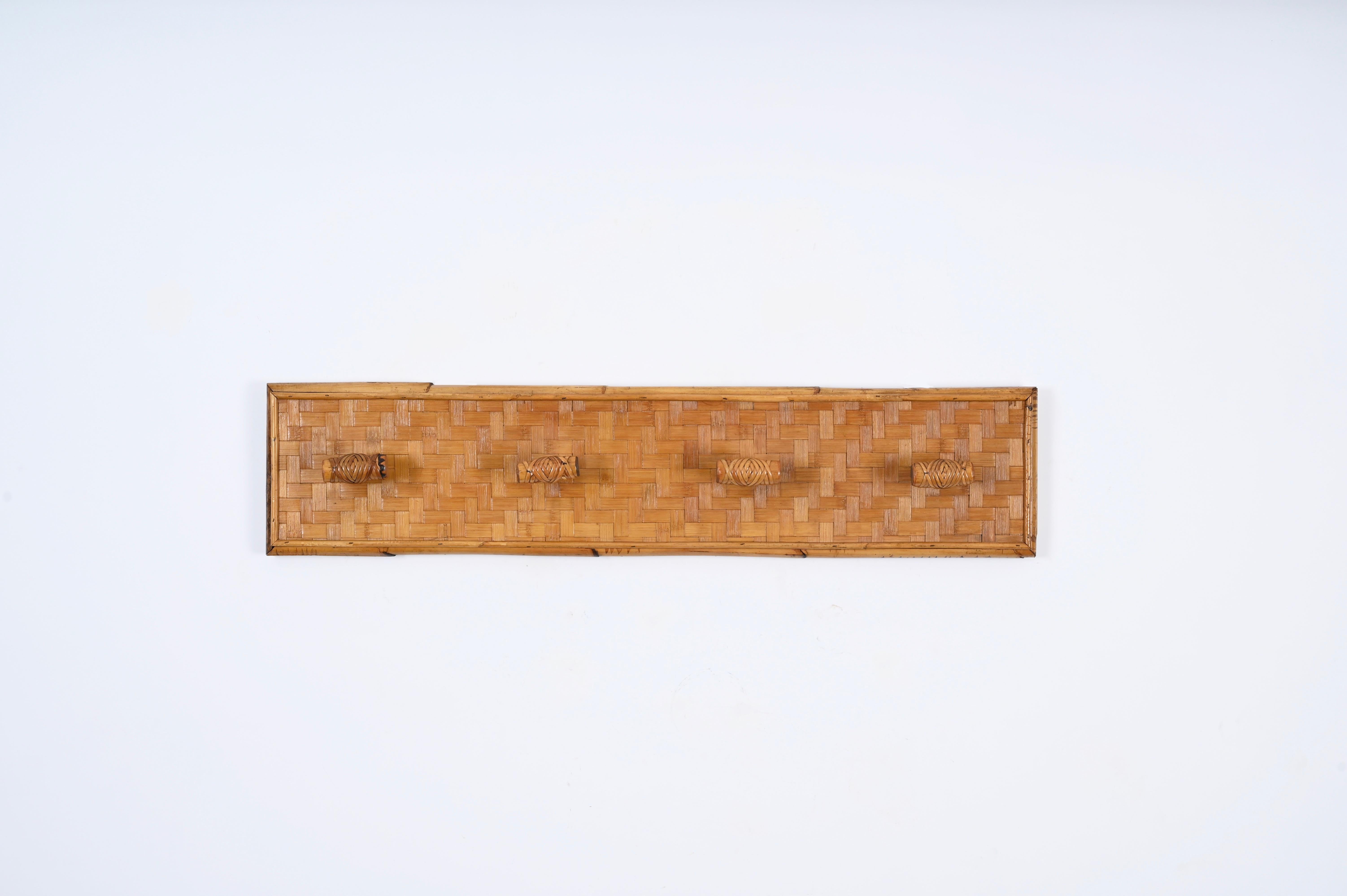 Stunning Mid-Century coat rack in woven rattan, wicker and bamboo. This gorgeous piece was designed in Italy in the 1960s. 

This coat rack features 4 lovely hooks decorated in  hand-woven wicker, the rectangular structure is enhanced with a