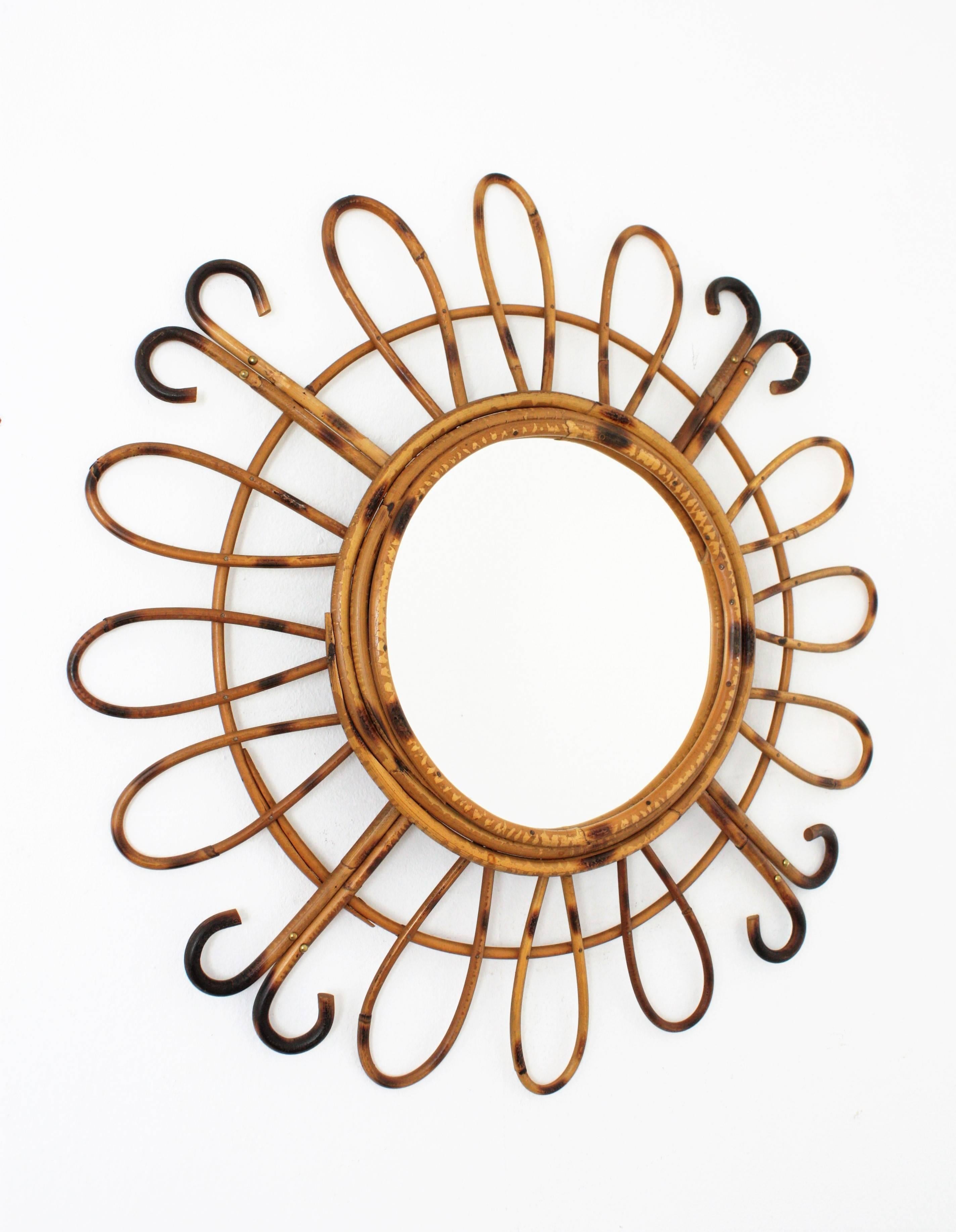 Beautiful handcrafted rattan and bamboo mirror with pyrography decoration .A circular glass framed by three bamboo cane laps and adorned by an alternating composition of three petals and two curved rays. This piece has all the taste of the French