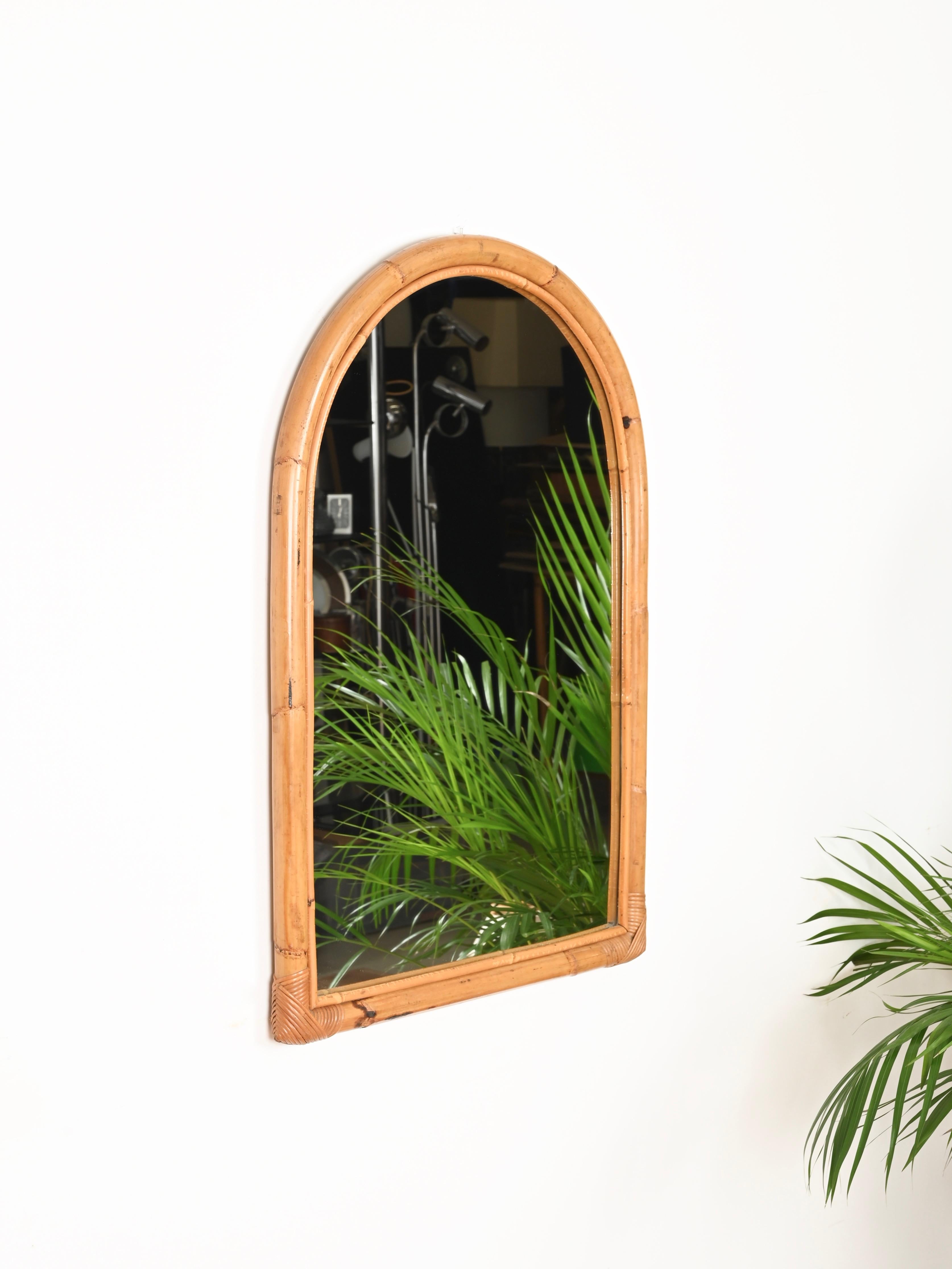 Superbe grand miroir arqué du milieu du siècle en bambou incurvé et rotin tressé à la main. Ce miroir organique de style Côte d'Azur a été produit en Italie dans les années 1960.

En très bon état et d'une charmante couleur miel, entièrement