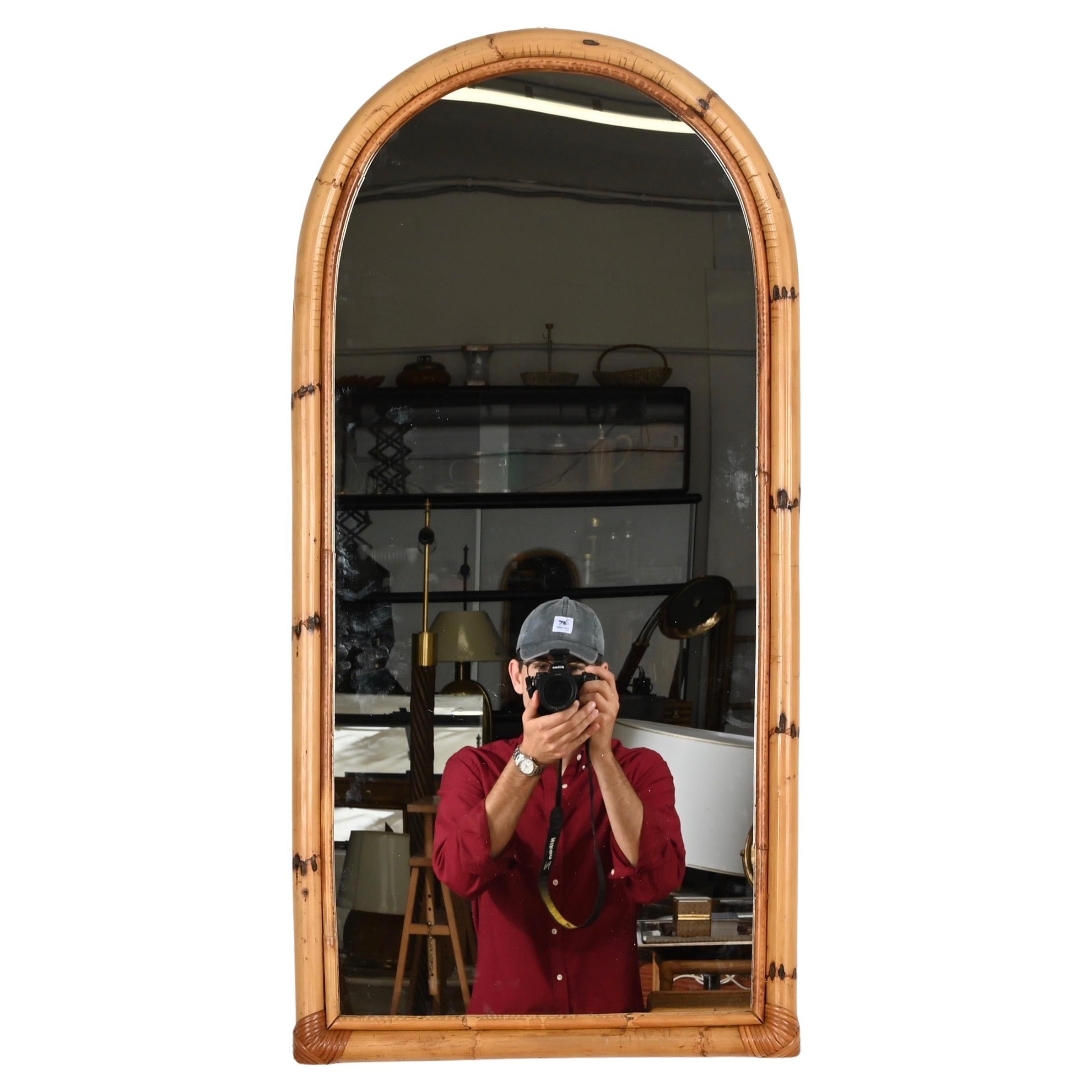 Splendido specchio ad arco del Mid-Century realizzato in bambù curvato, rattan e vimini intrecciato a mano. Questo grazioso e unico specchio organico in stile Costa Azzurra è stato prodotto in Italia negli anni Settanta.

In condizioni fantastiche e